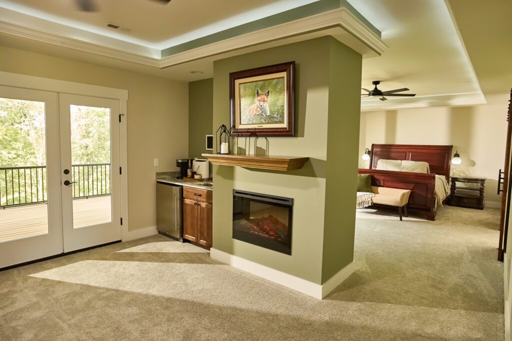 Finished master bedroom with built-in fireplace and recessed ceiling lighting