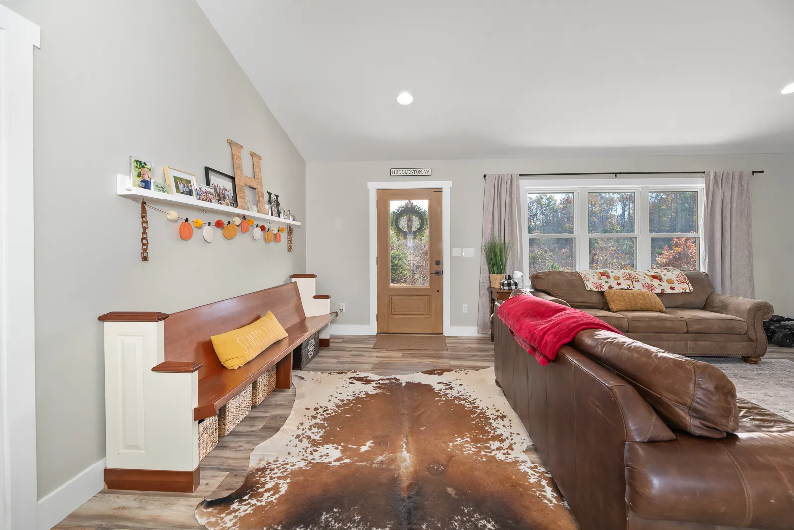 Living room and entry with church-pew bench in the Carter's Mill Home