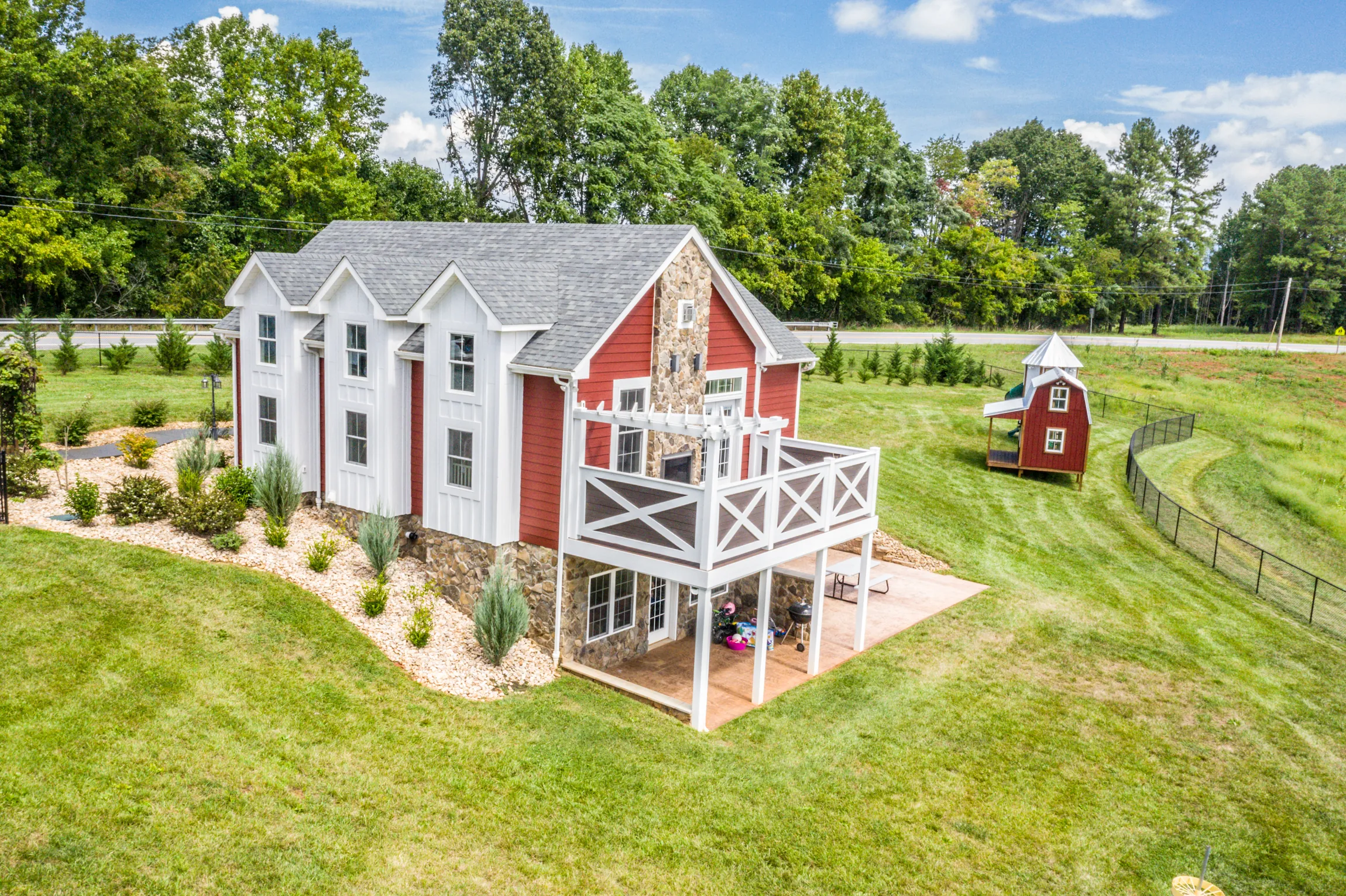 Aerial view of the Lowry Home with red siding, stone and upper deck
