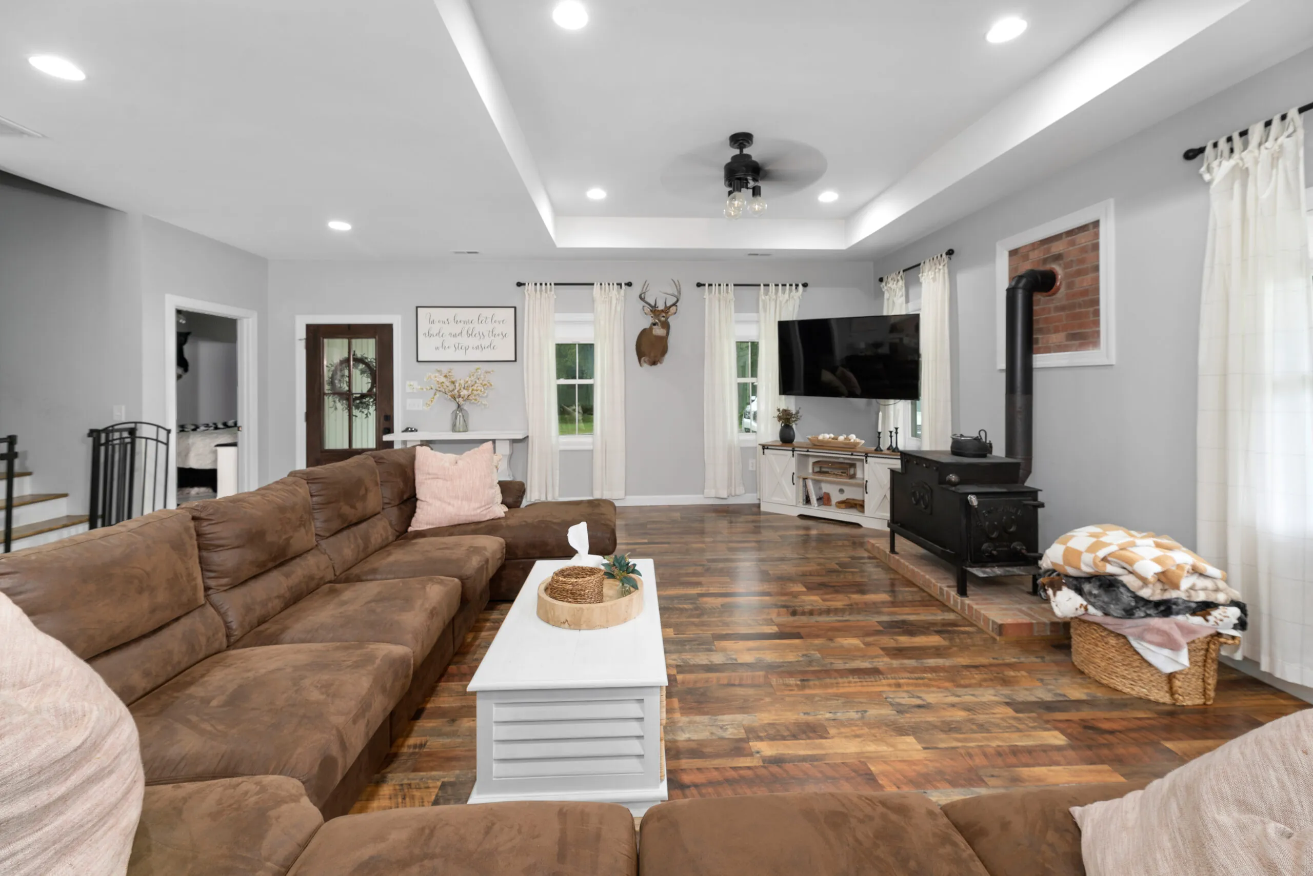 Living room with sectional sofa and wood stove in the Peters Creek Home