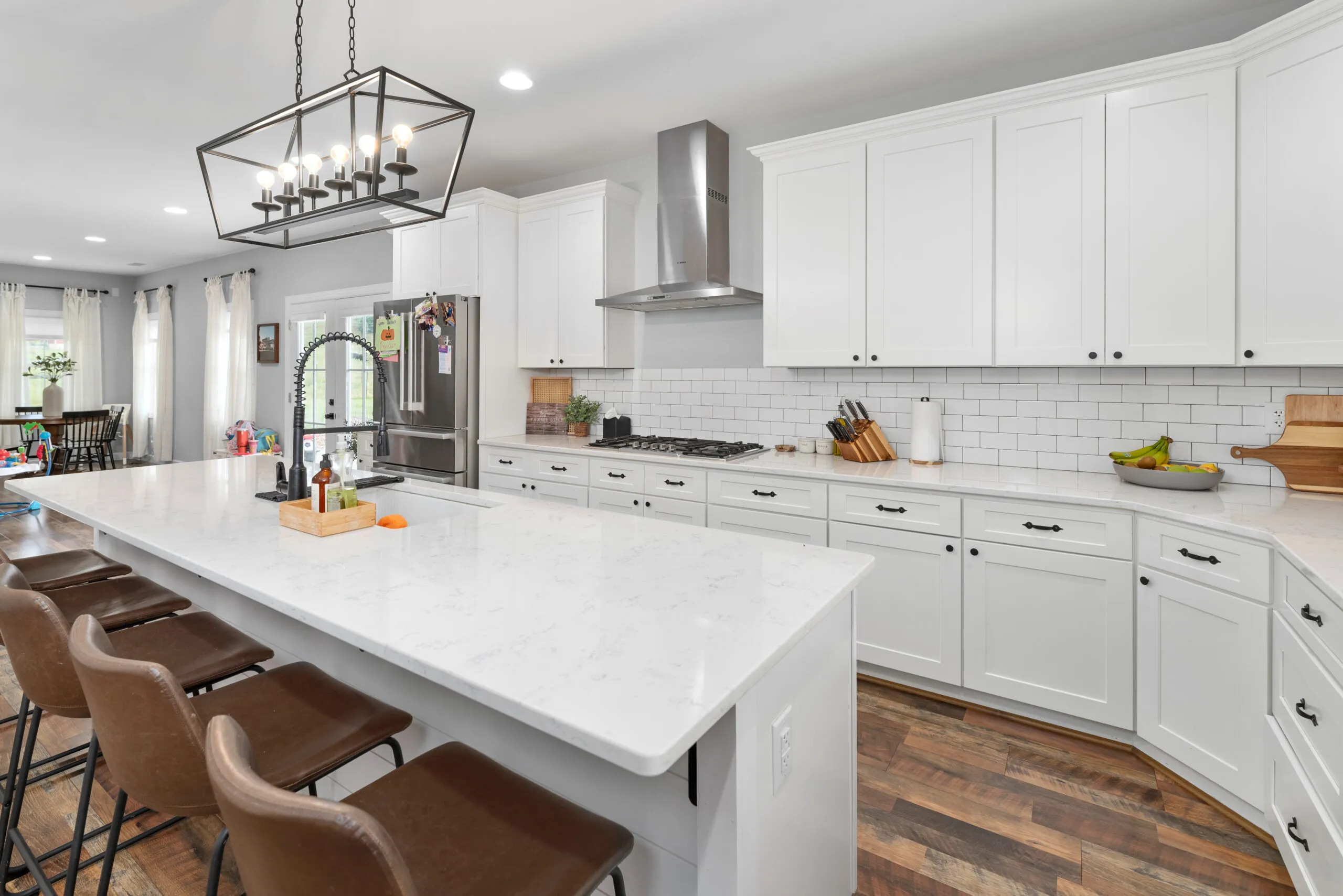 Kitchen island with bar stools and white cabinets in the Peters Creek Home
