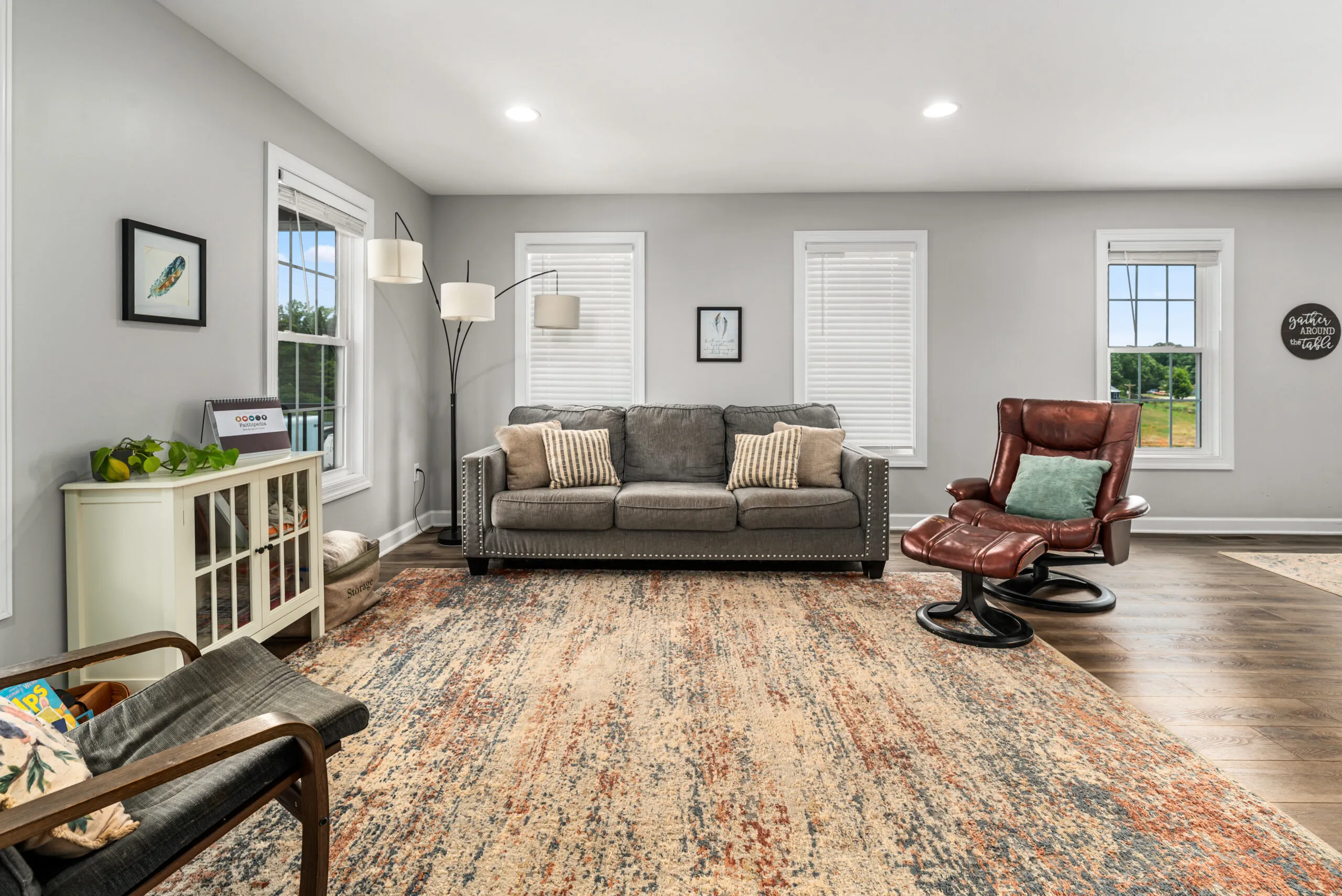 Living room with sofa, leather chair and area rug in the Timber Ridge Home
