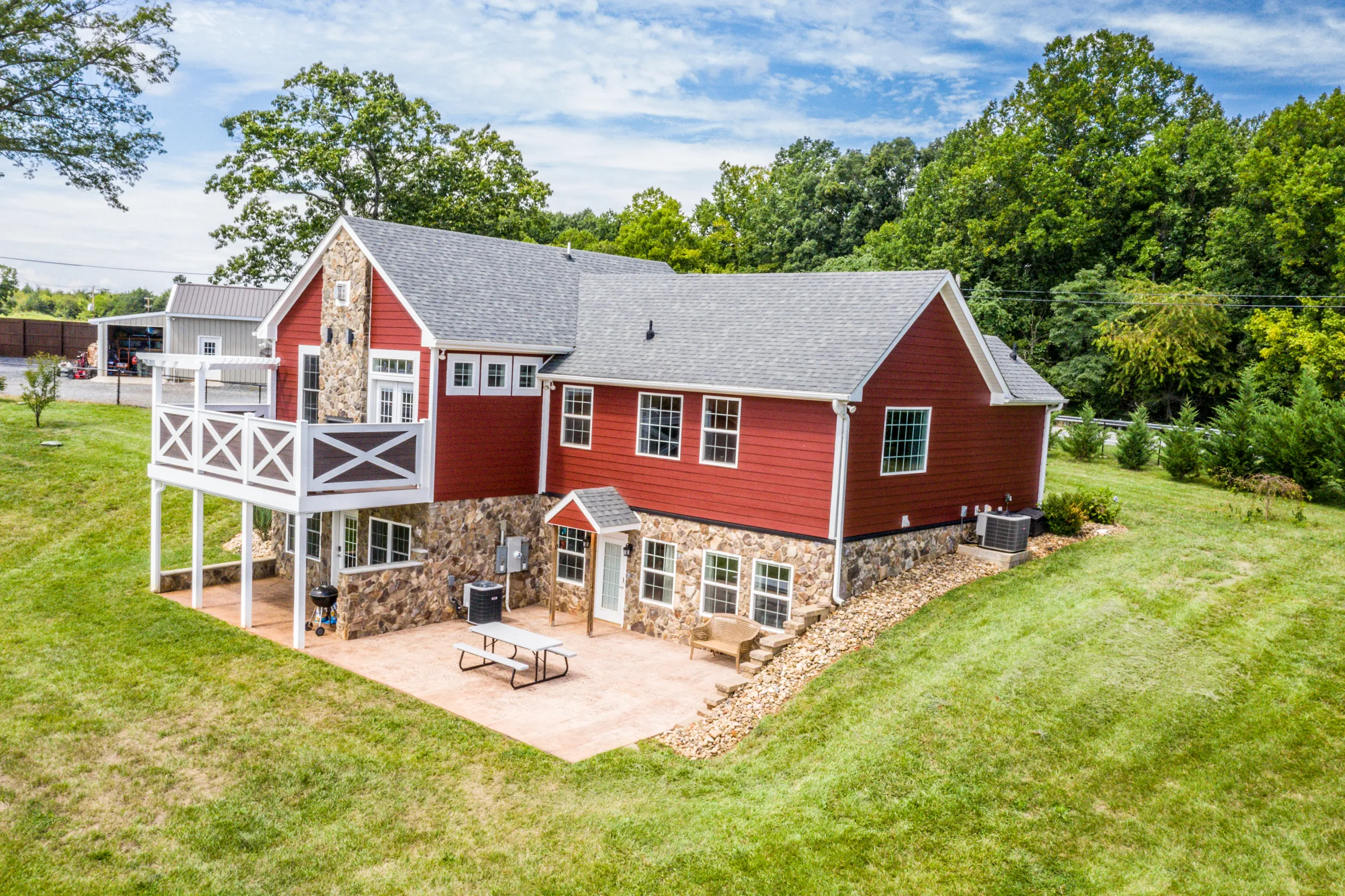 Aerial rear view of the Lowry Home with stone patio and upper deck