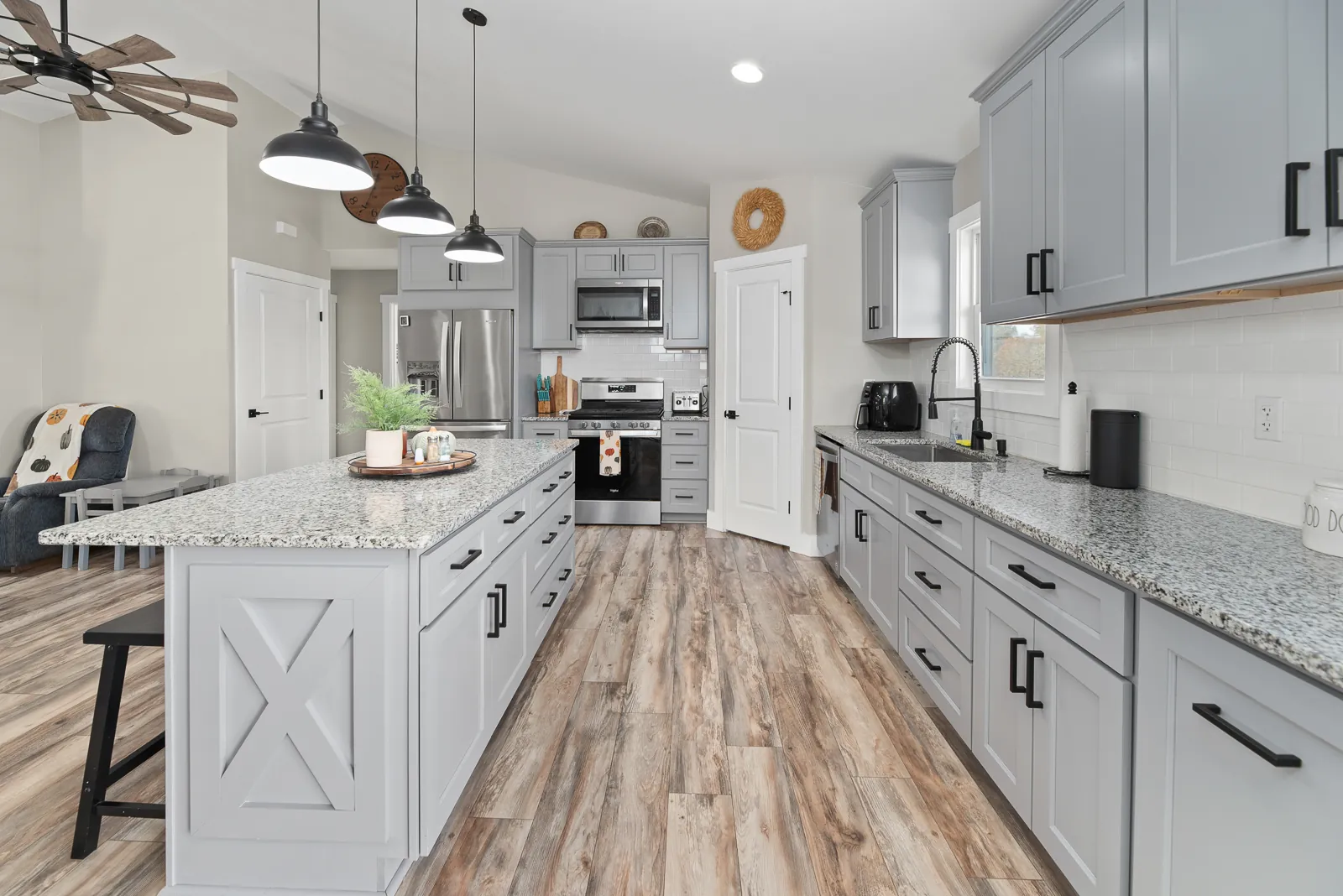 Kitchen with gray cabinets and granite island in the Carter's Mill Home