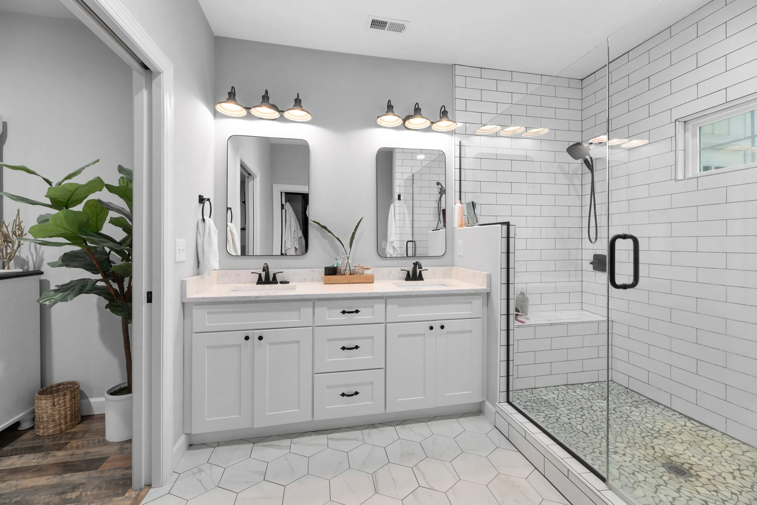 Primary bathroom with double vanity and tiled glass shower in the Peters Creek Home