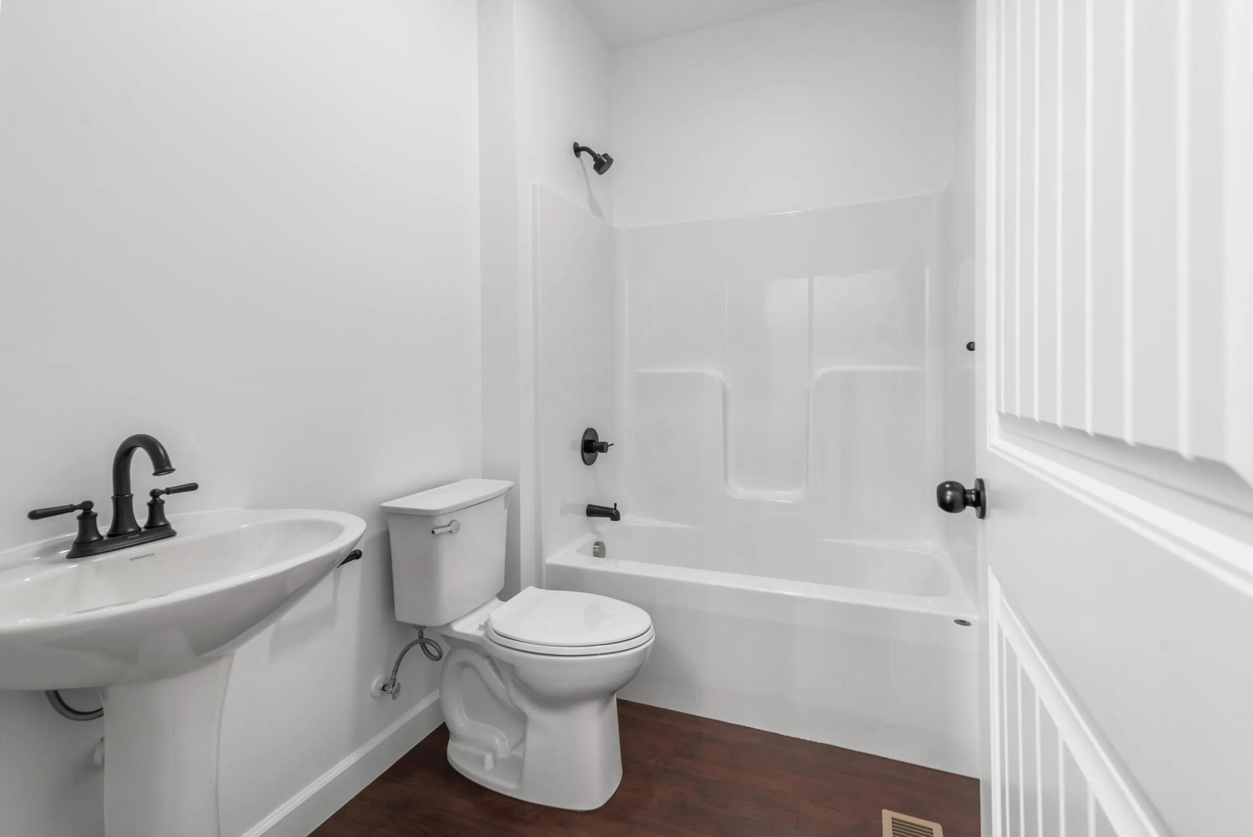 Full bathroom with pedestal sink and tub-shower in the Otterlea Home