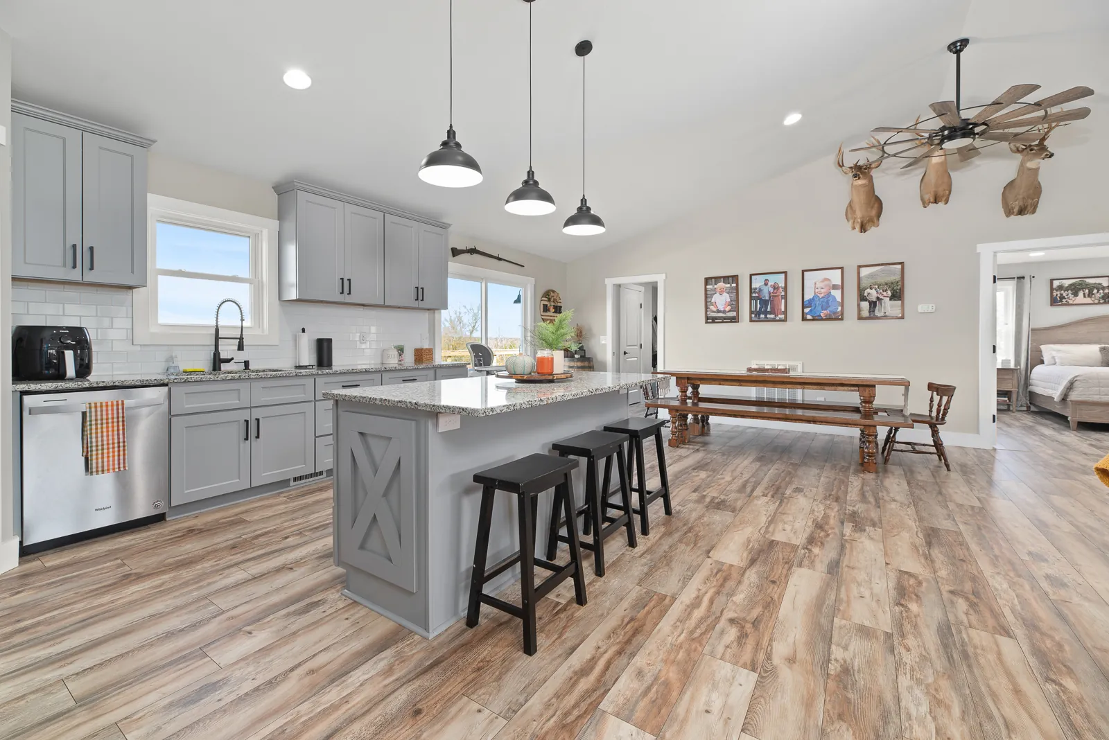 Kitchen with gray cabinets, island and dining table in the Carter's Mill Home