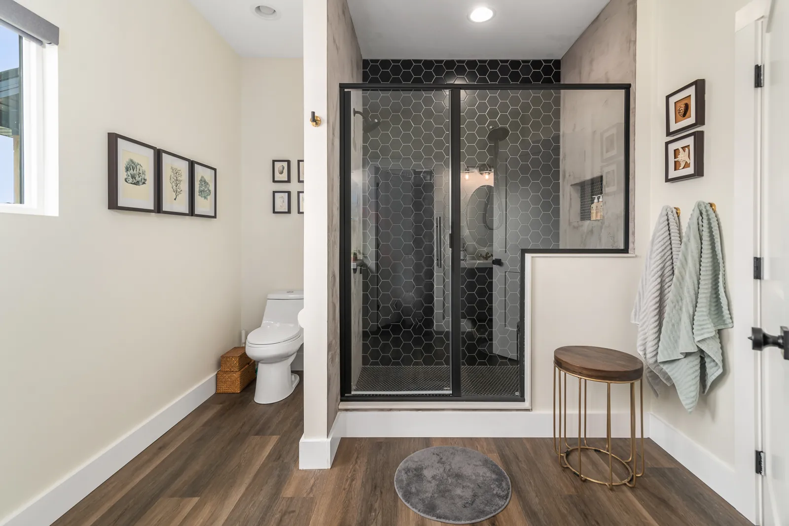 Primary bathroom with black hex-tile walk-in shower in the LynBrook Home