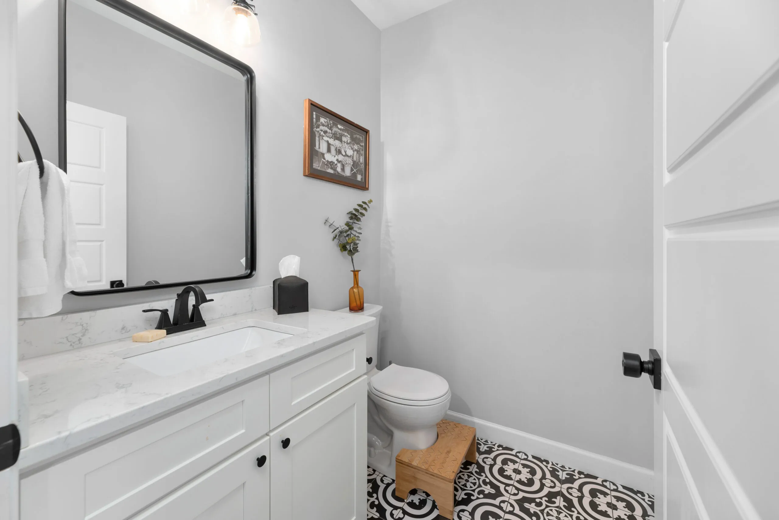 Powder room with black-and-white patterned tile floor in the Peters Creek Home