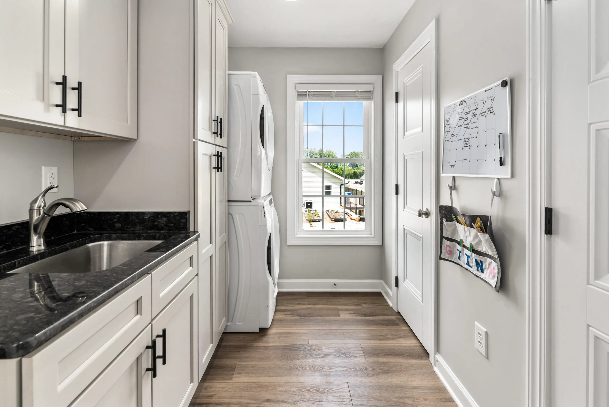 Laundry room with stacked washer and dryer and utility sink in the Timber Ridge Home
