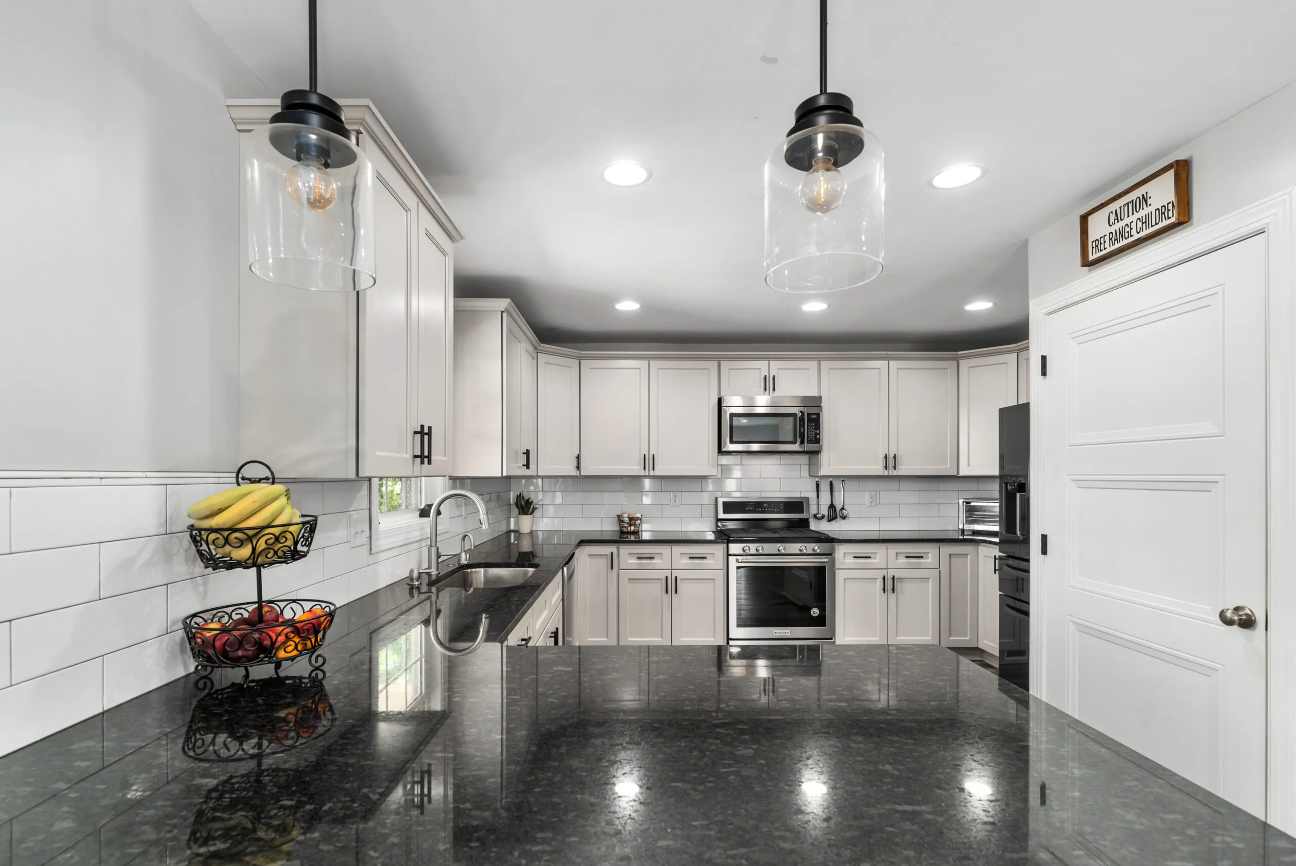 Kitchen with pendant lights and black granite counters in the Timber Ridge Home