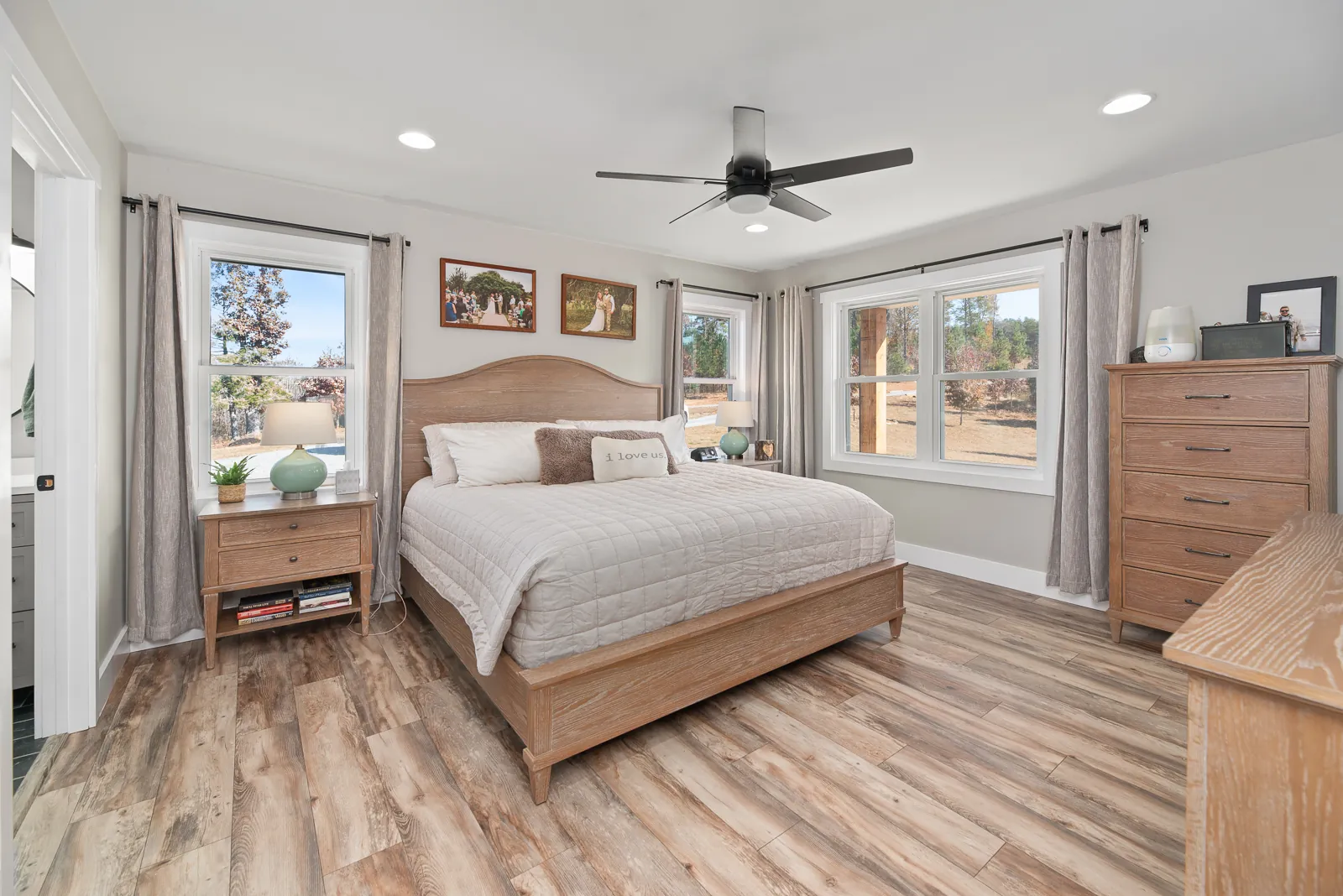 Primary bedroom with wood bed and ceiling fan in the Carter's Mill Home
