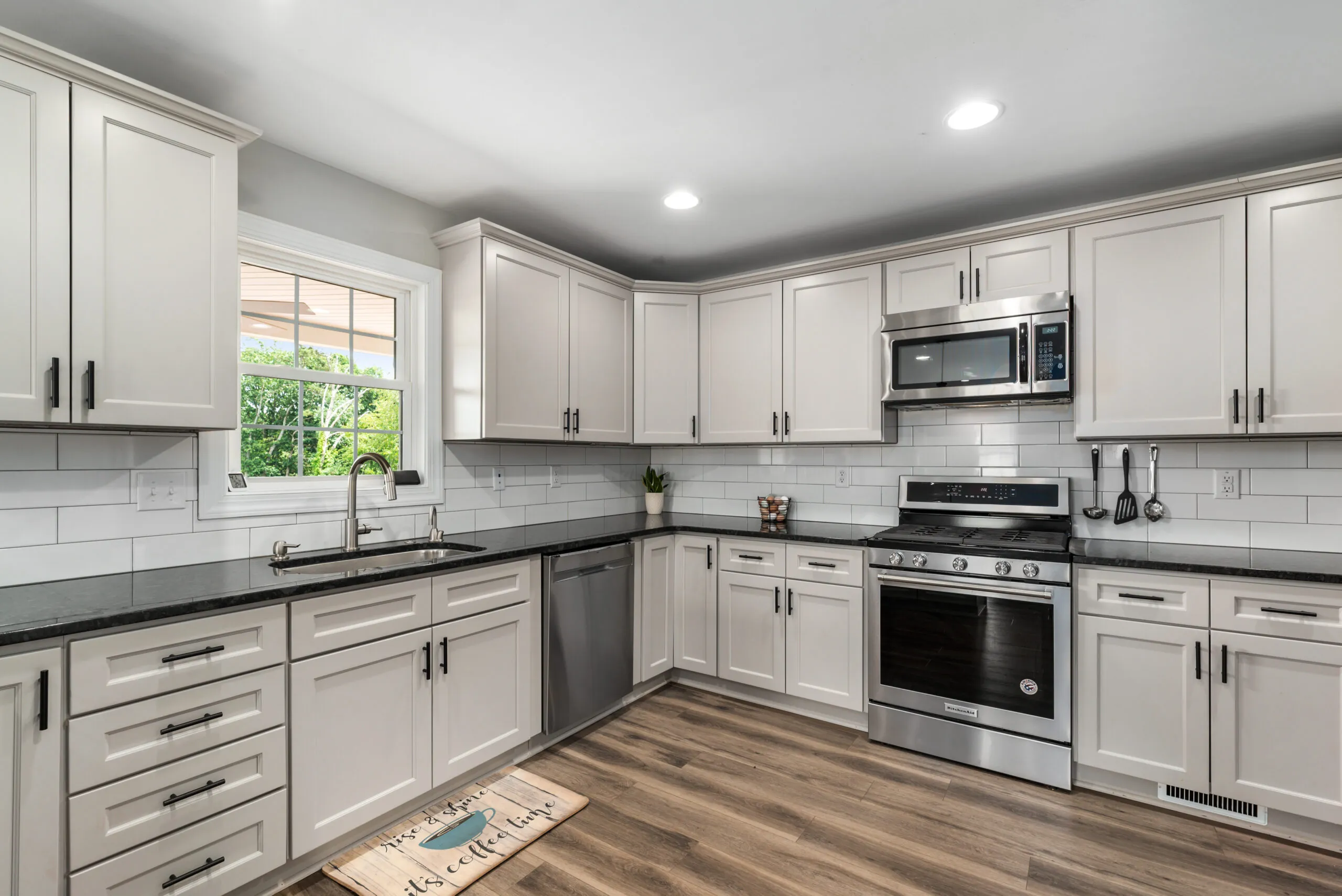 Kitchen sink and gas range with white shaker cabinets in the Timber Ridge Home