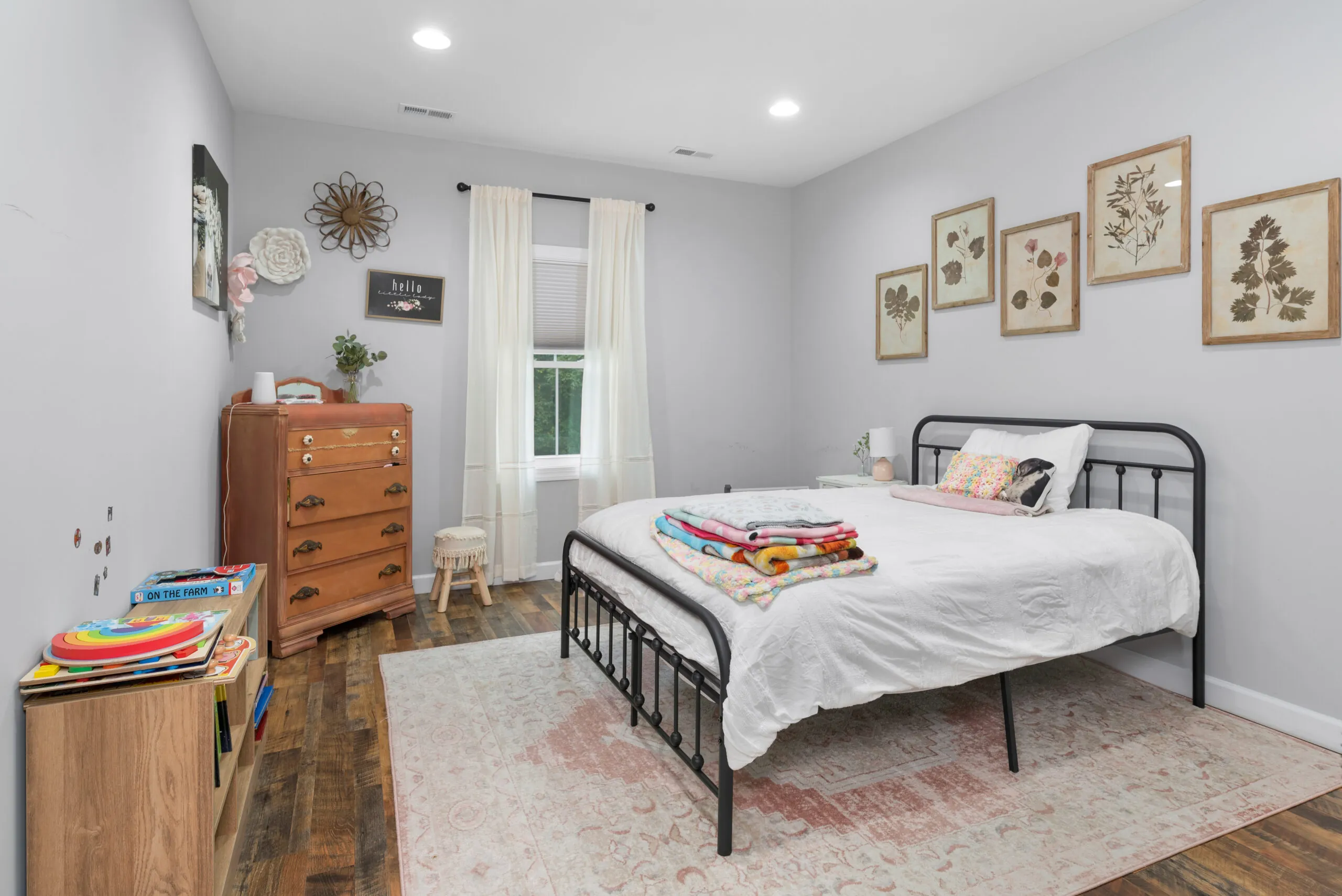 Bedroom with iron bed and framed botanical prints in the Peters Creek Home