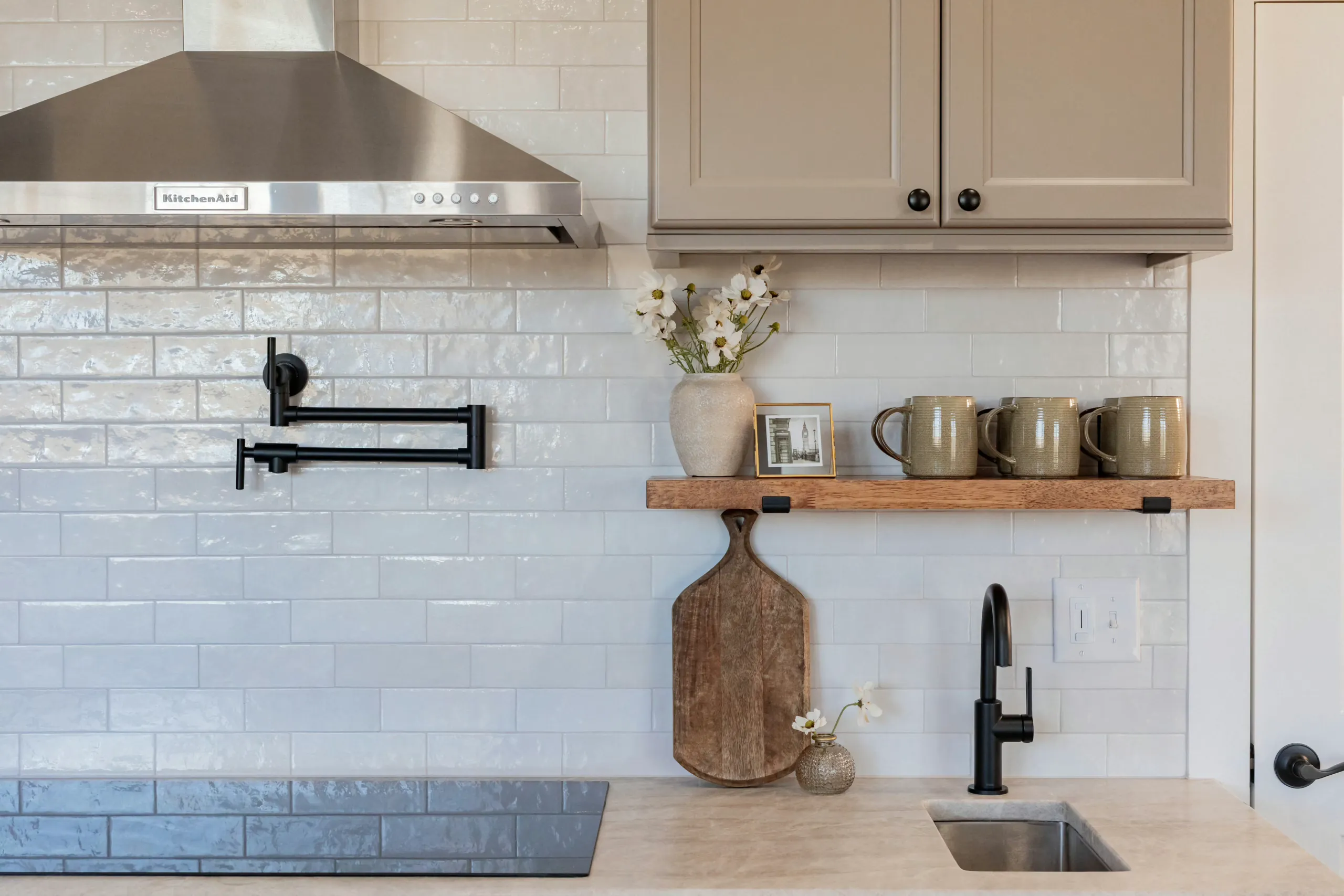Cedar Fox Home kitchen backsplash with pot filler, open shelf with mugs and black faucet