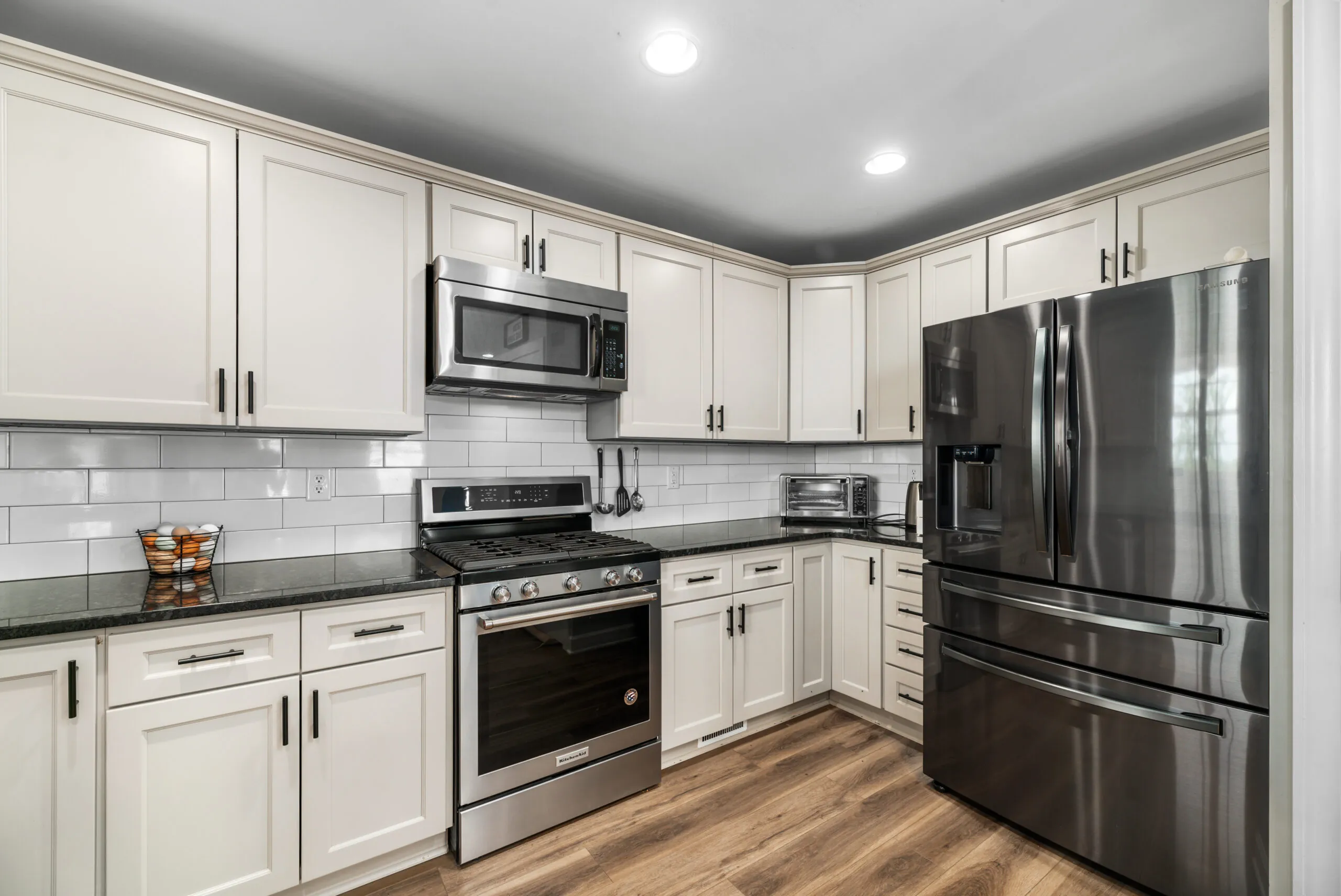 Kitchen with white cabinets, black granite and stainless appliances in the Timber Ridge Home