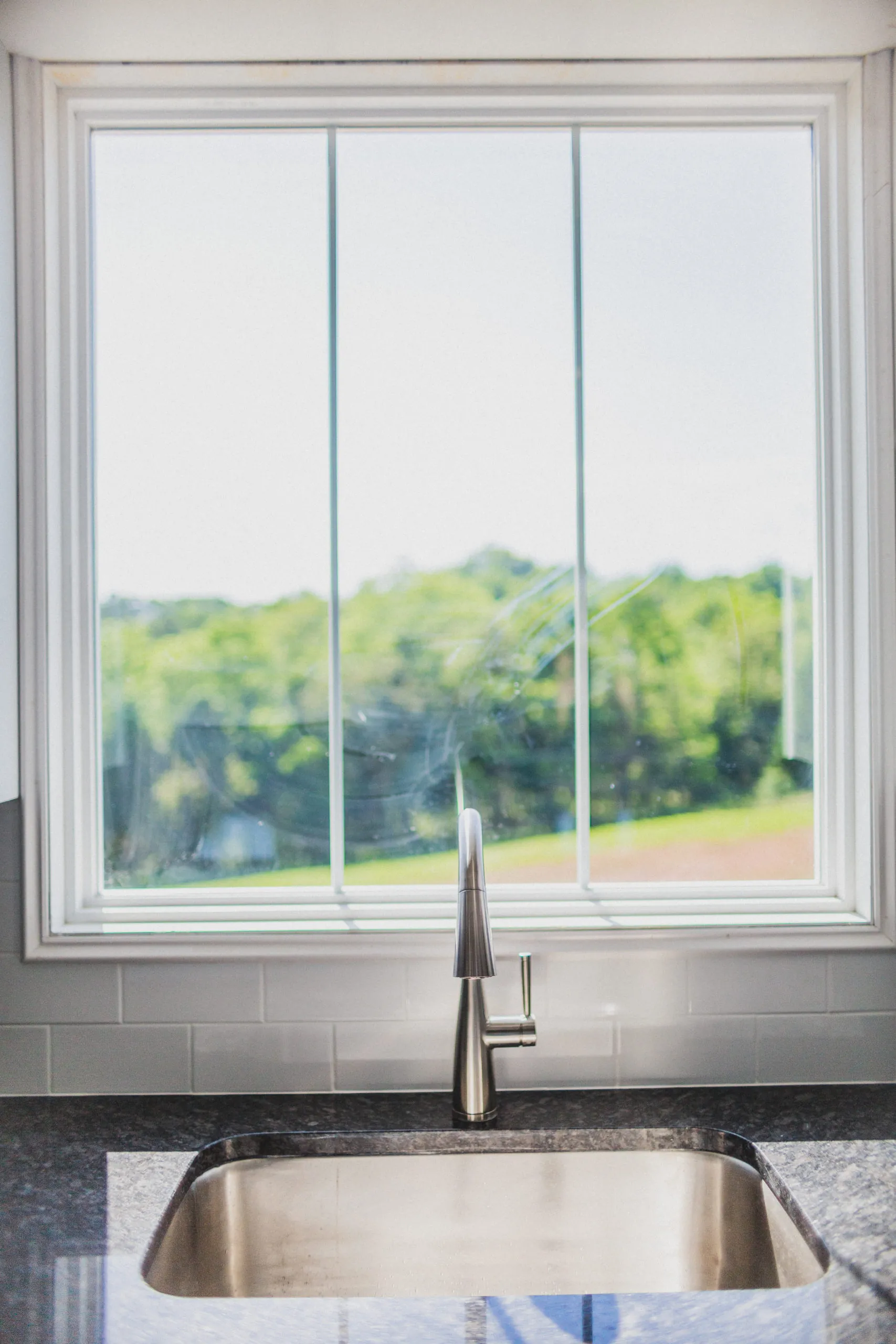 Kitchen sink and faucet under a large window in the Falling Creek Home