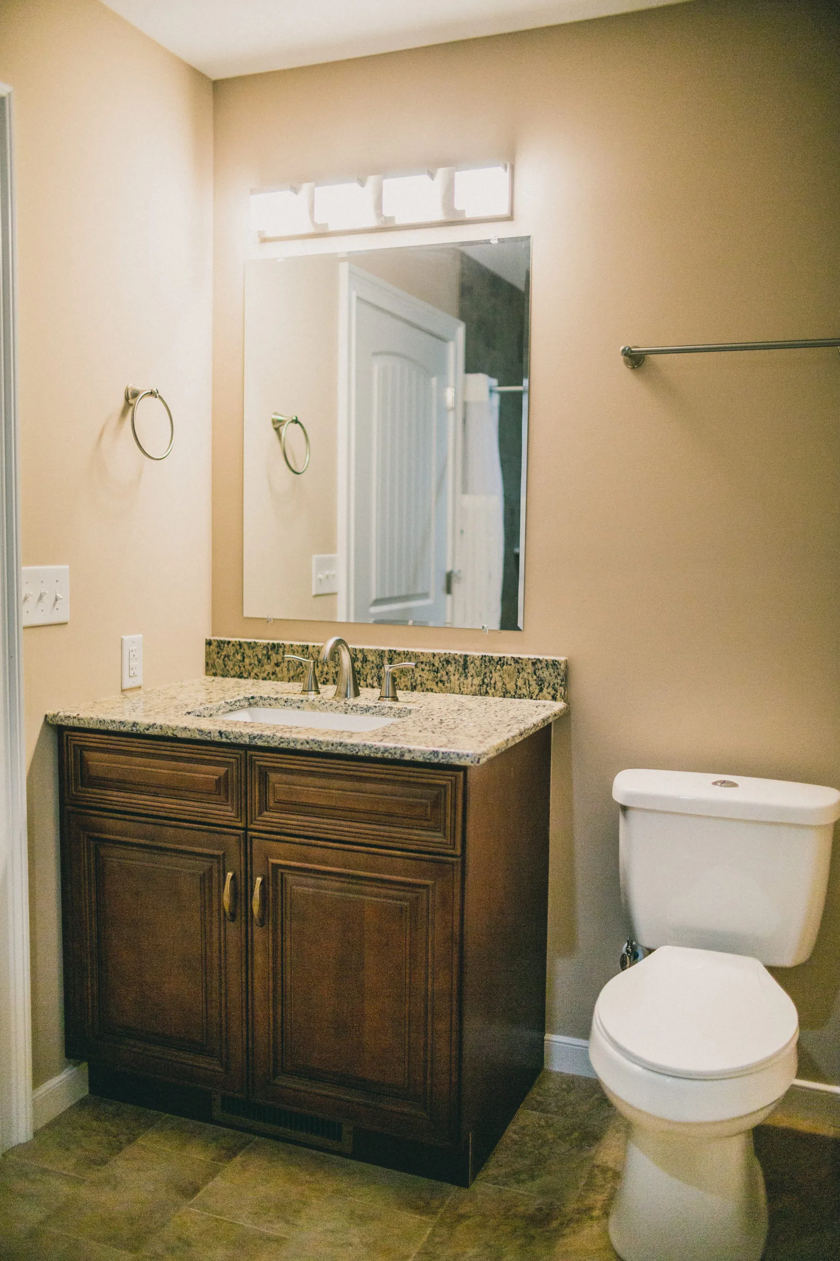 Bathroom vanity with granite top and dark wood cabinet in the Forest Home
