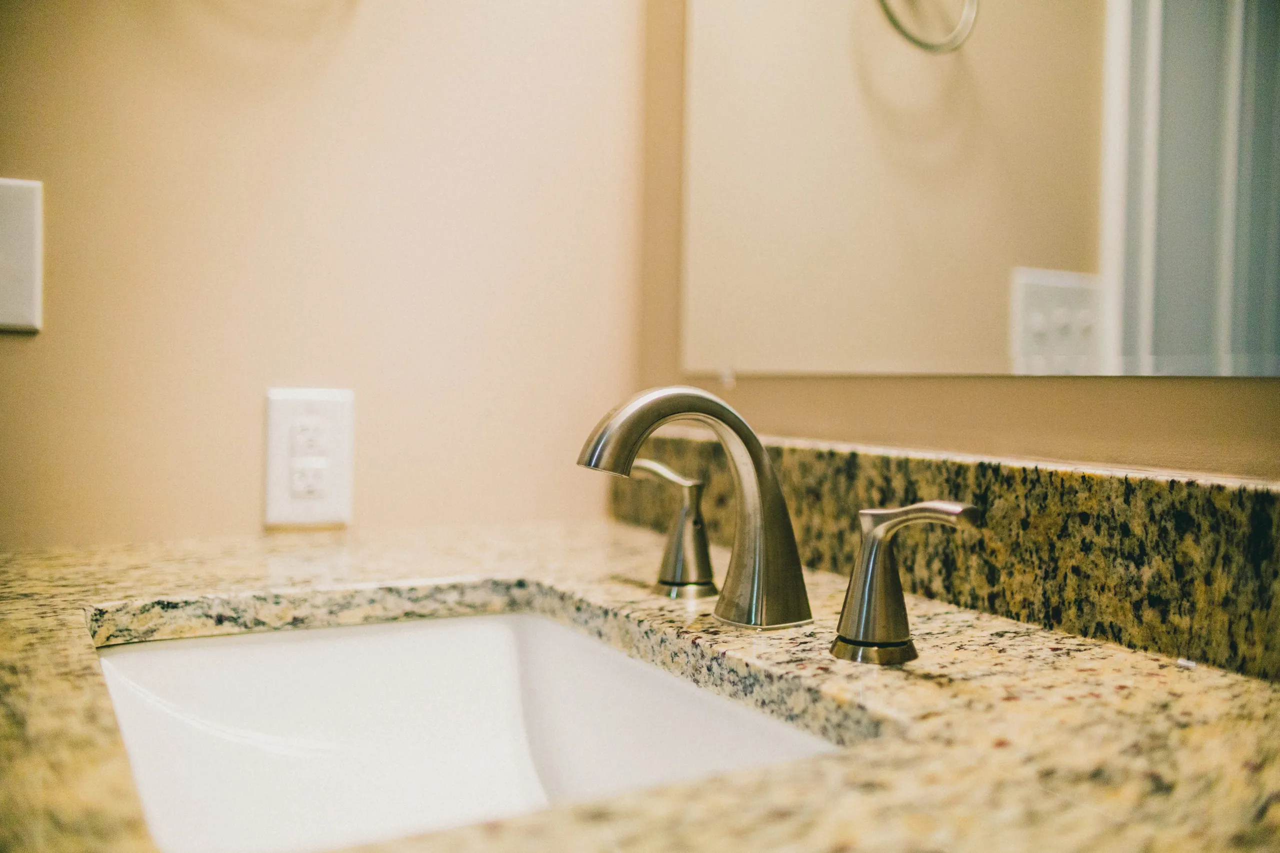 Bathroom faucet and granite countertop in the Forest Home