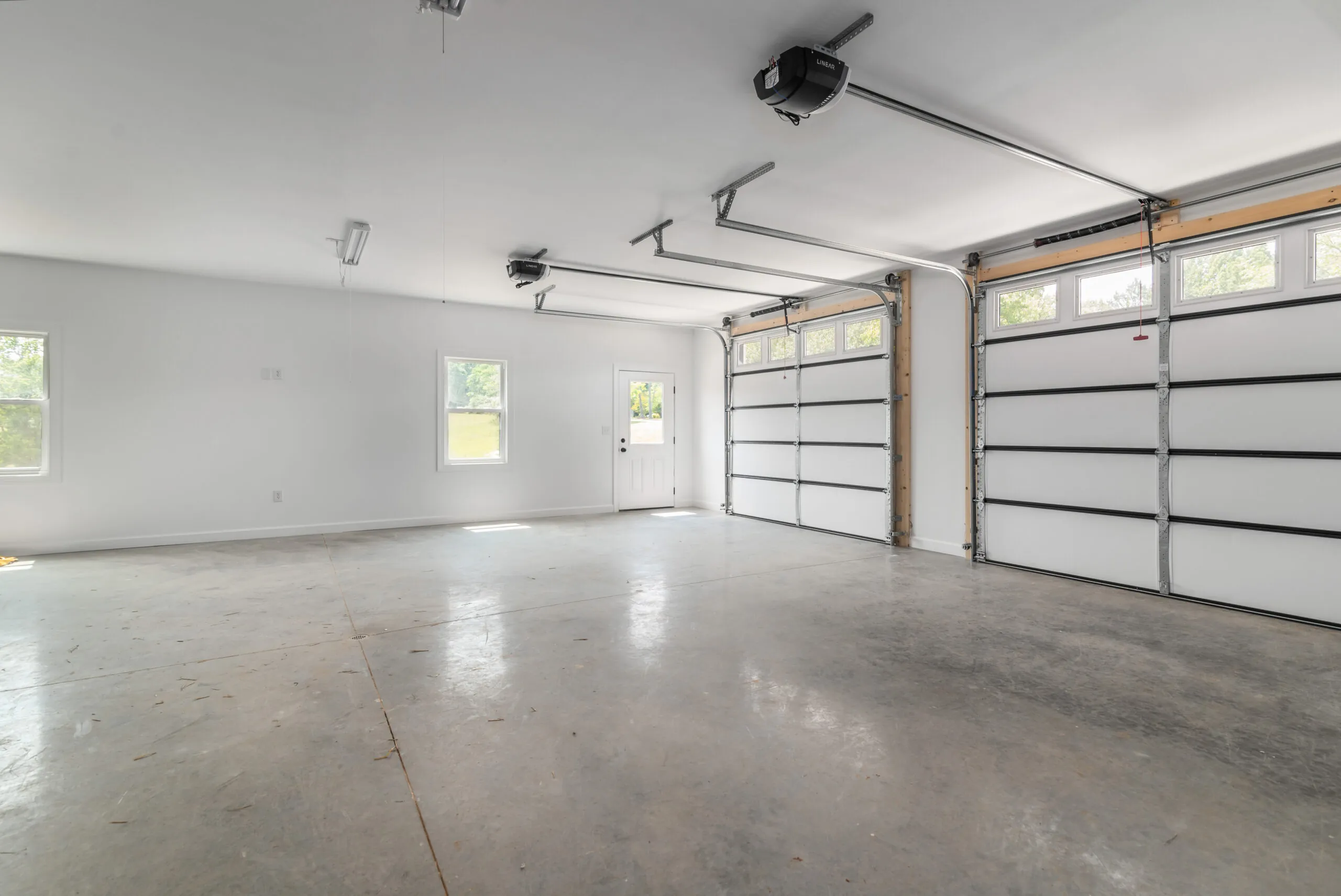 Three-car garage interior with concrete floor in the Otterlea Home