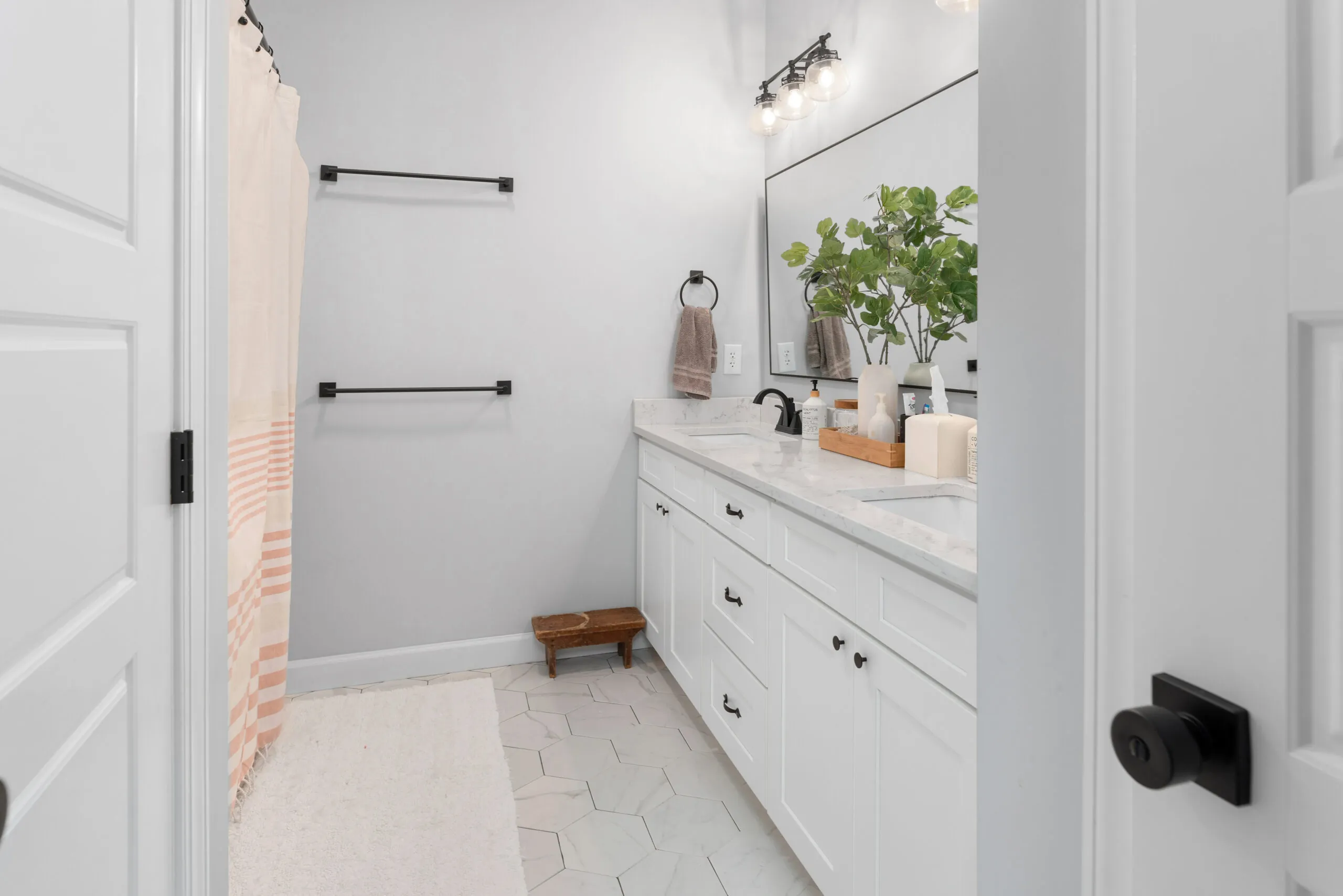 Hall bathroom with white double vanity and hex tile floor in the Peters Creek Home