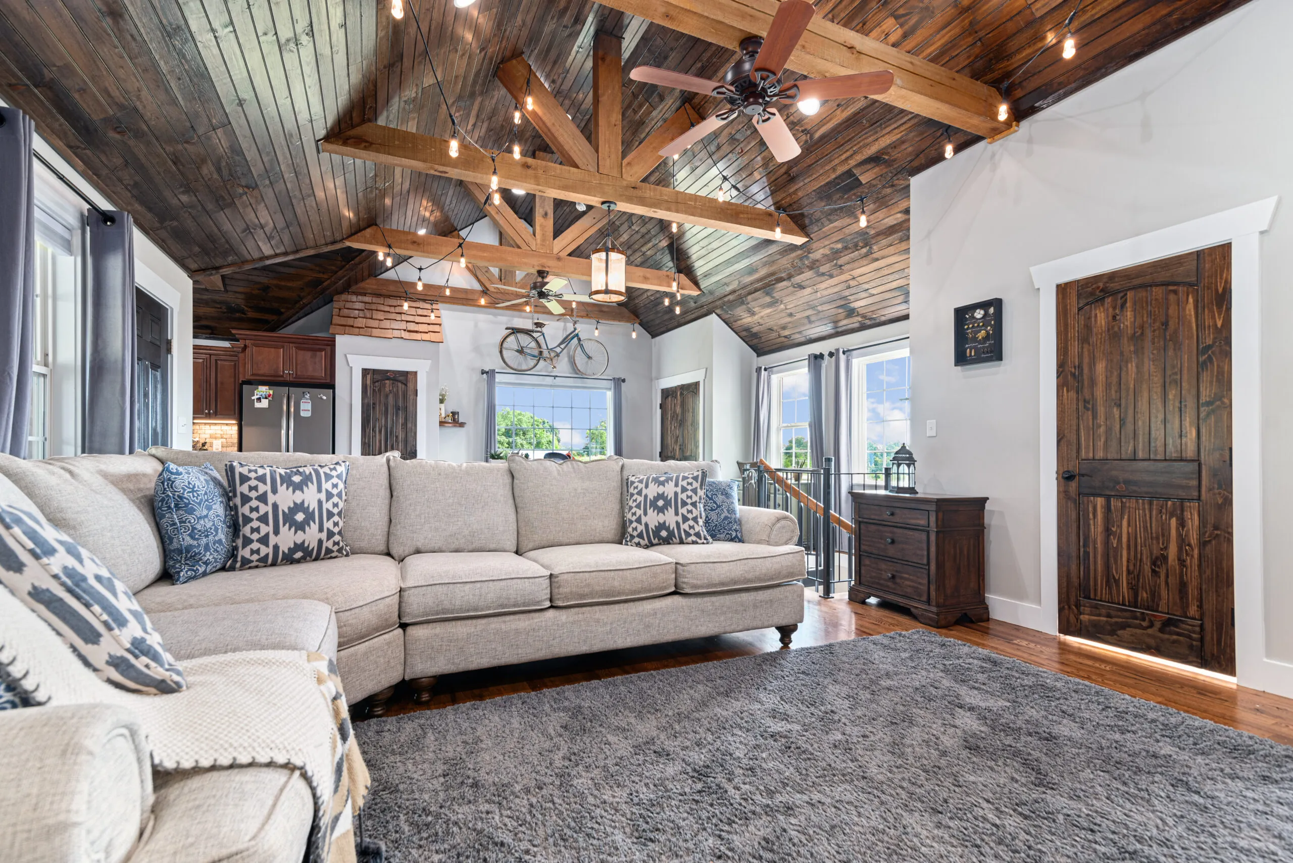 Living room with sectional sofa and timber-beam vaulted ceiling in the Lowry Home