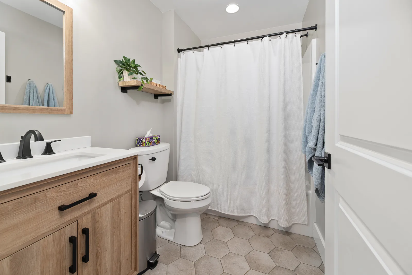 Full bathroom with wood vanity and tub-shower in the Carter's Mill Home