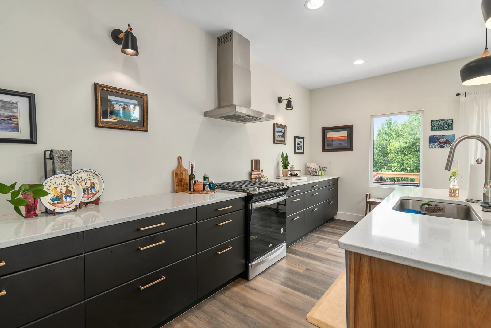 Kitchen with dark cabinets, brass pulls and range hood in the LynBrook Home