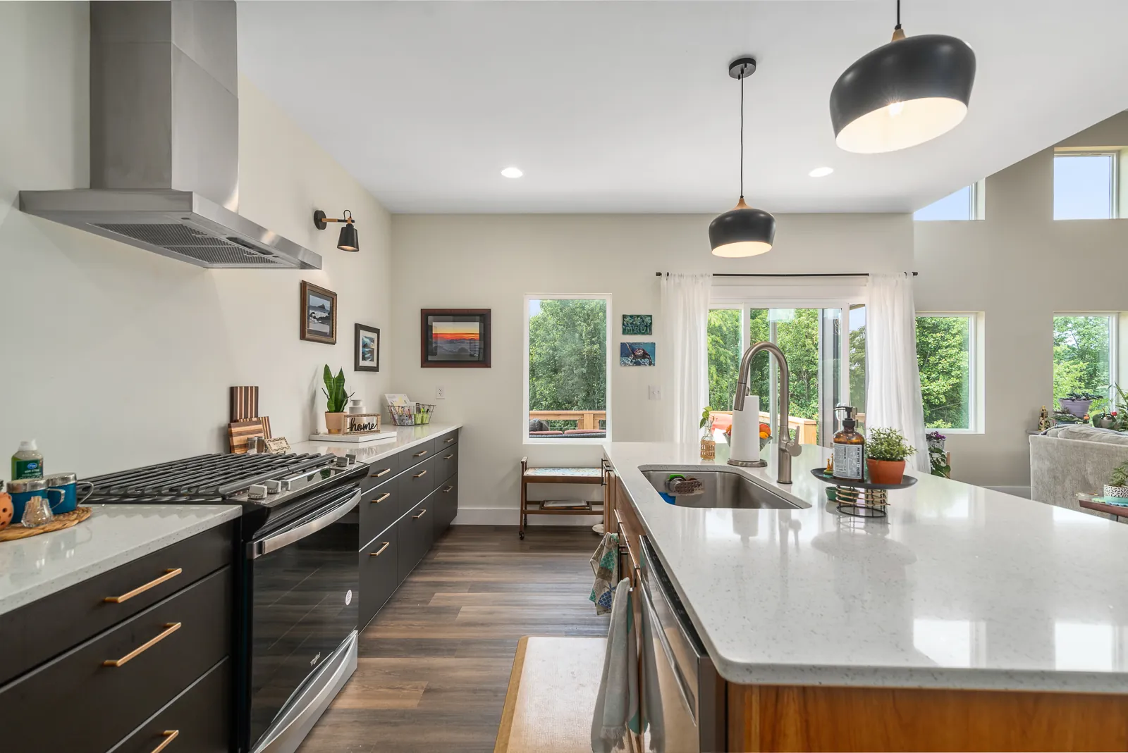 Kitchen with dark cabinets, brass pulls and wood-front island in the LynBrook Home