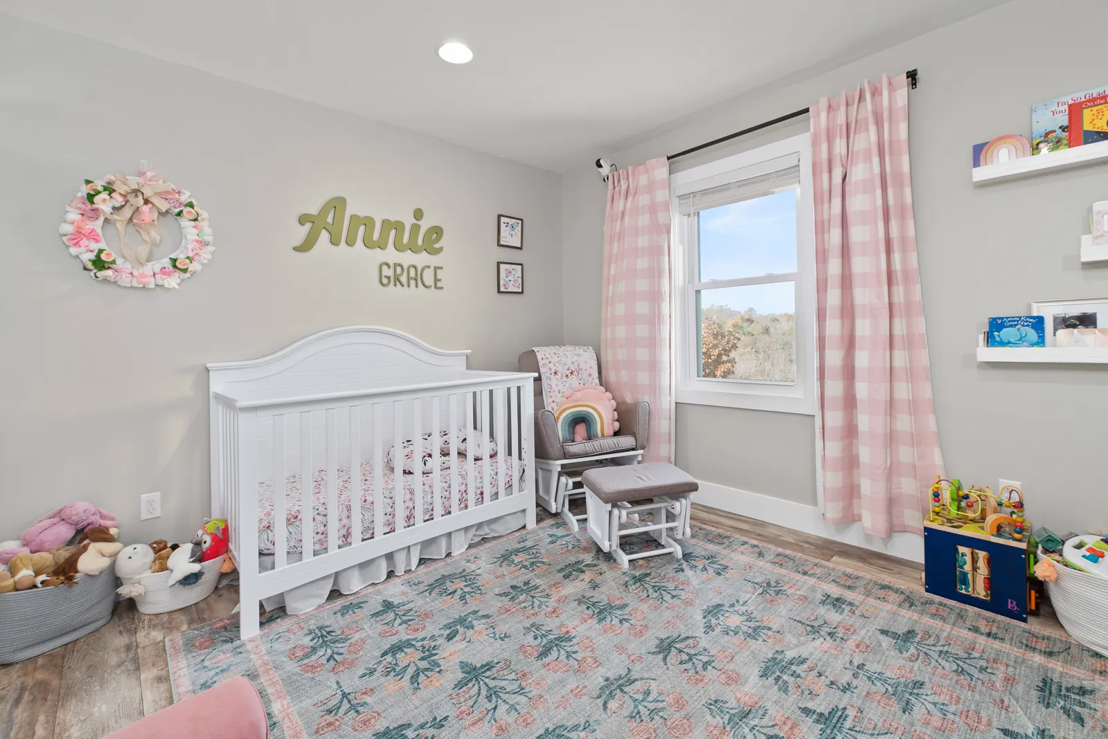 Girl's nursery with white crib and pink gingham curtains in the Carter's Mill Home