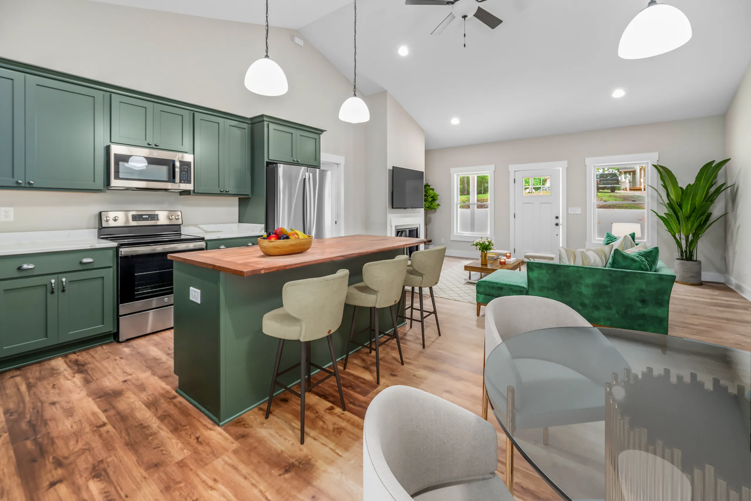 Open kitchen with green island and living room beyond in the Lake Crest Home