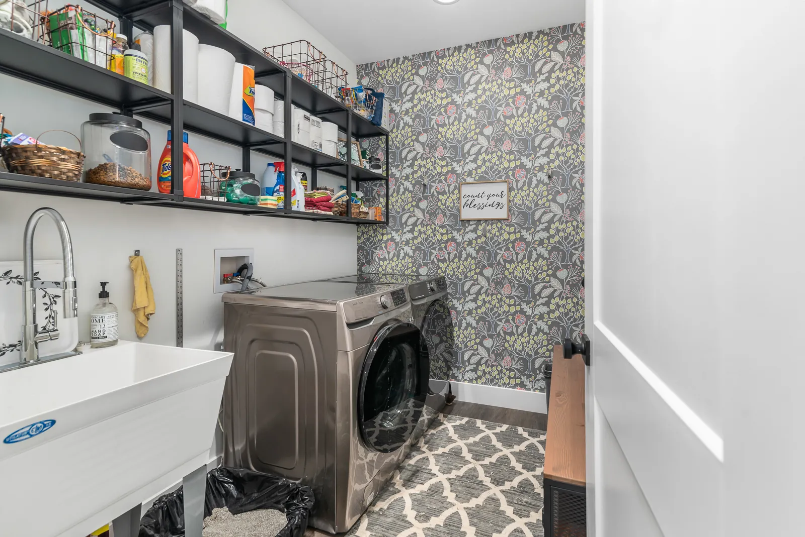 Laundry room with washer, dryer, utility sink and wallpaper in the LynBrook Home