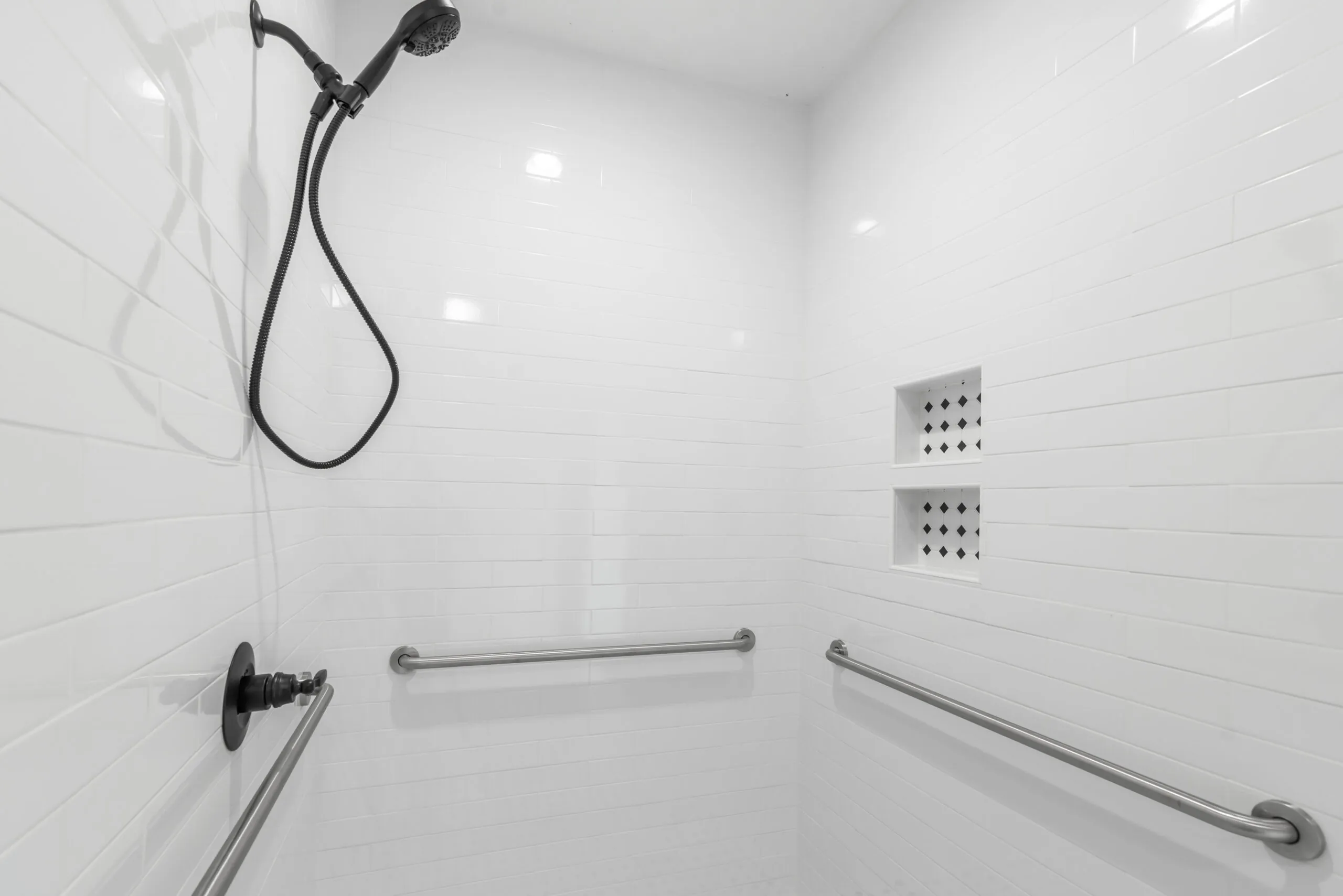 White subway tile shower with grab bars and niche in the Otterlea Home