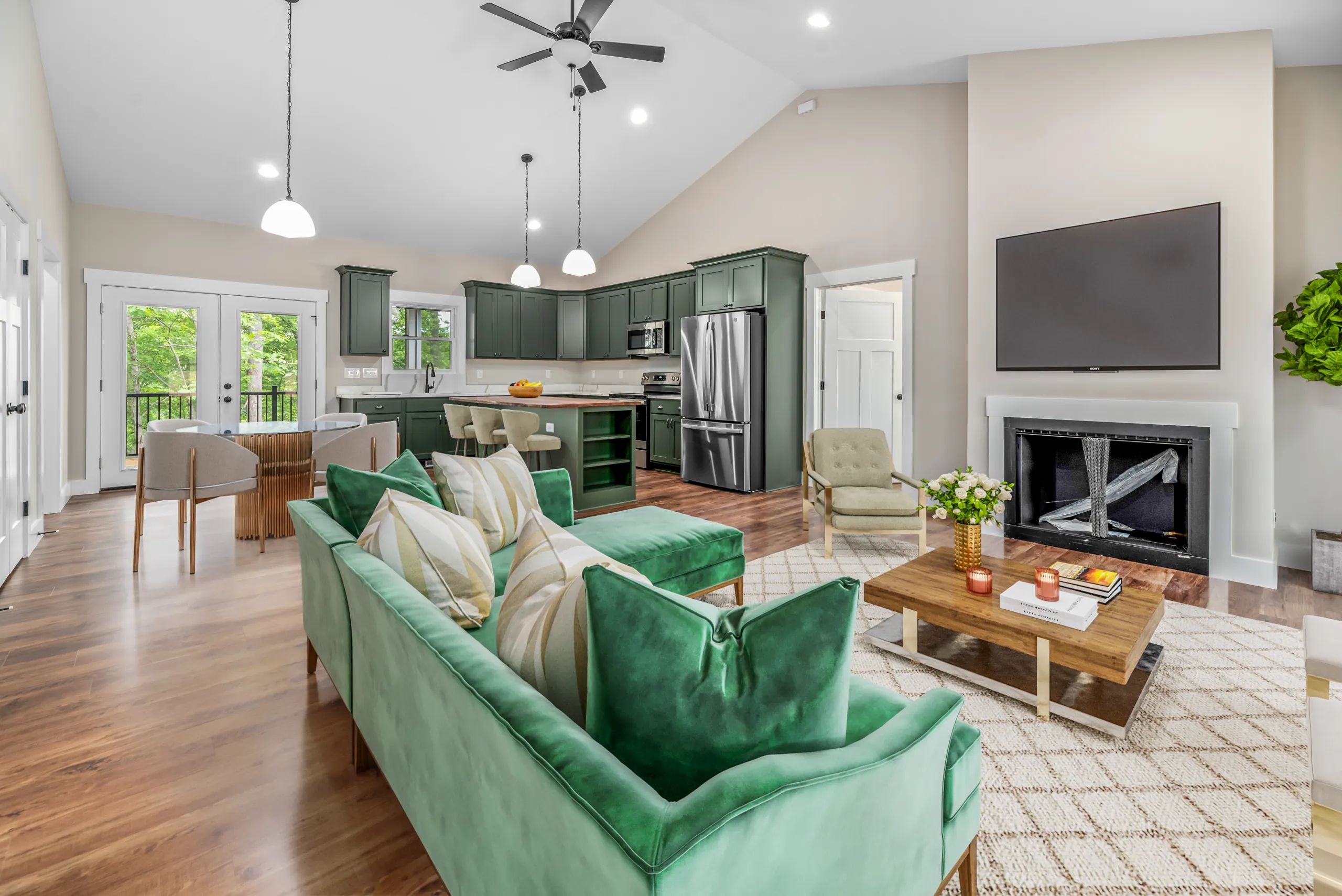 Living room with fireplace and vaulted ceiling open to the kitchen in the Lake Crest Home