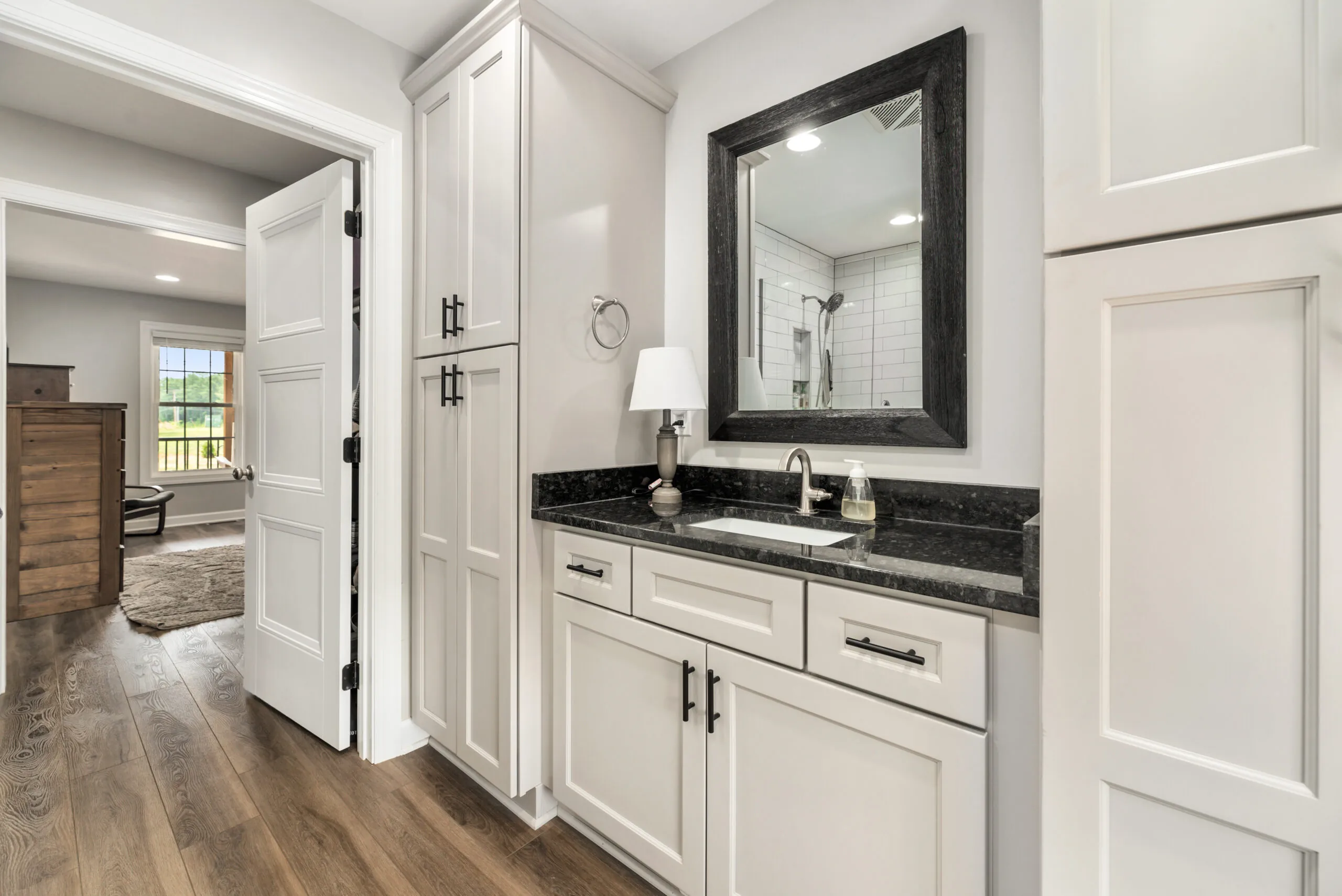 Primary bathroom vanity with open door to bedroom in the Timber Ridge Home