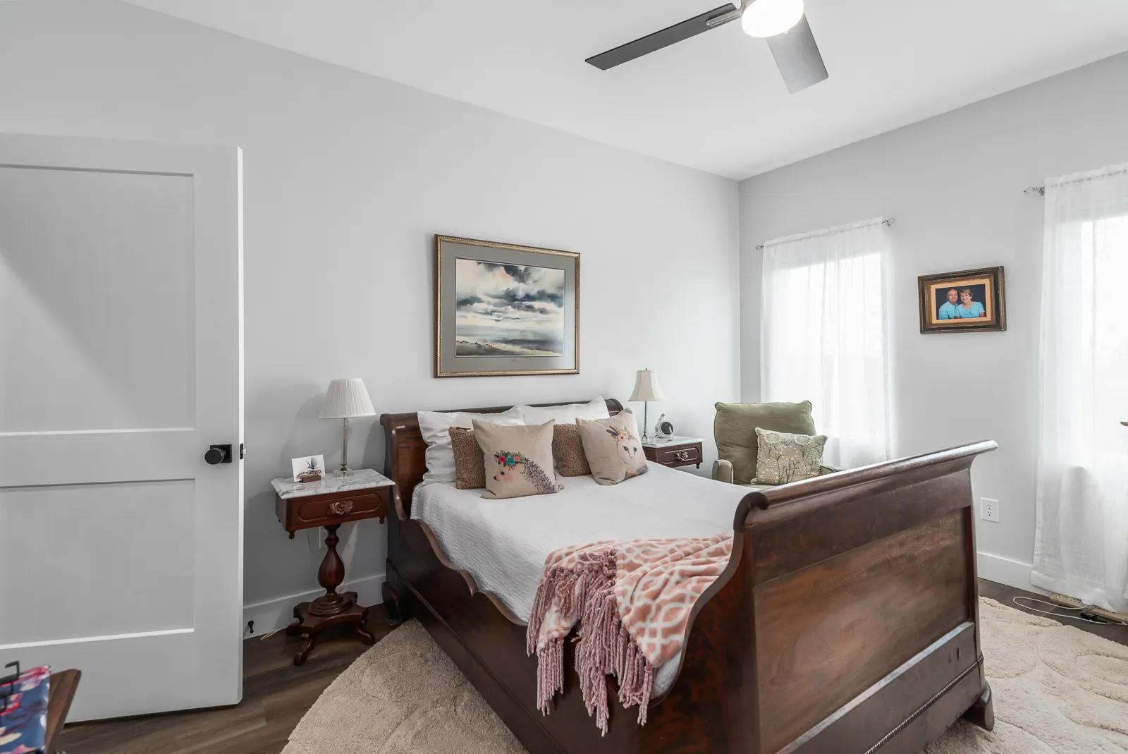Guest bedroom with sleigh bed and soft natural light in the LynBrook Home