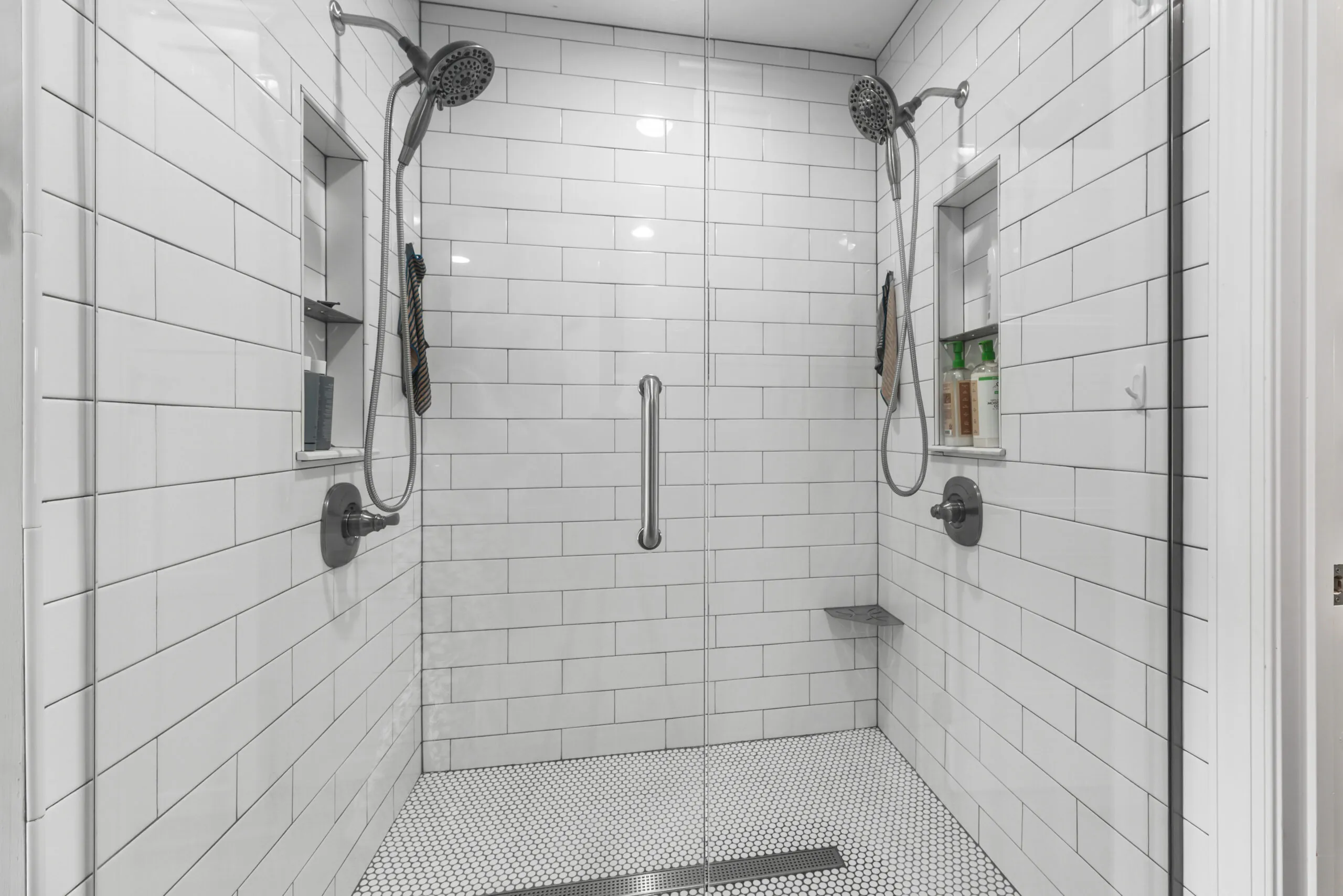 Walk-in tile shower with dual shower heads in the Timber Ridge Home primary bath