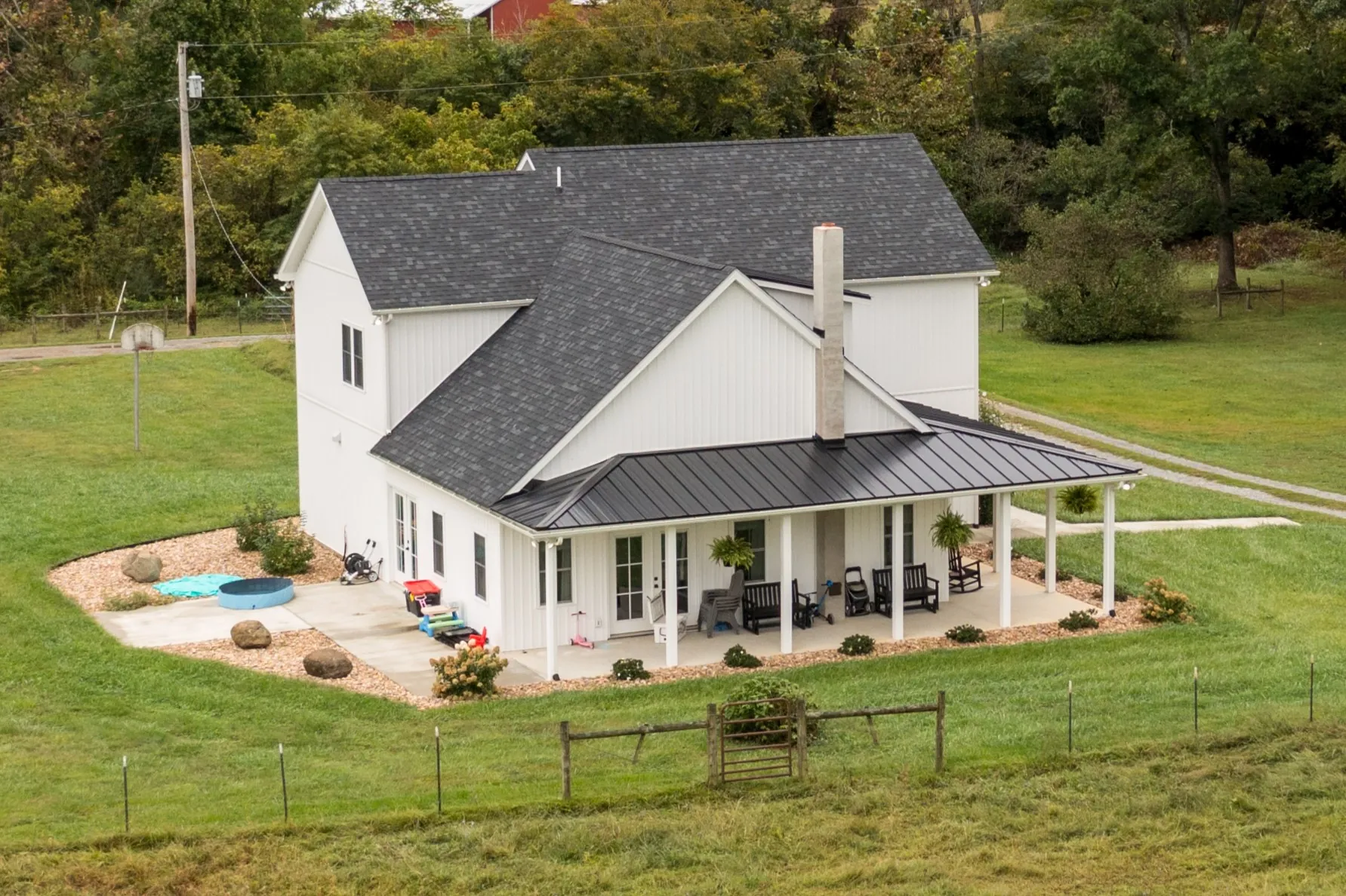 Aerial view of the Peters Creek Home with metal-roofed wraparound porch