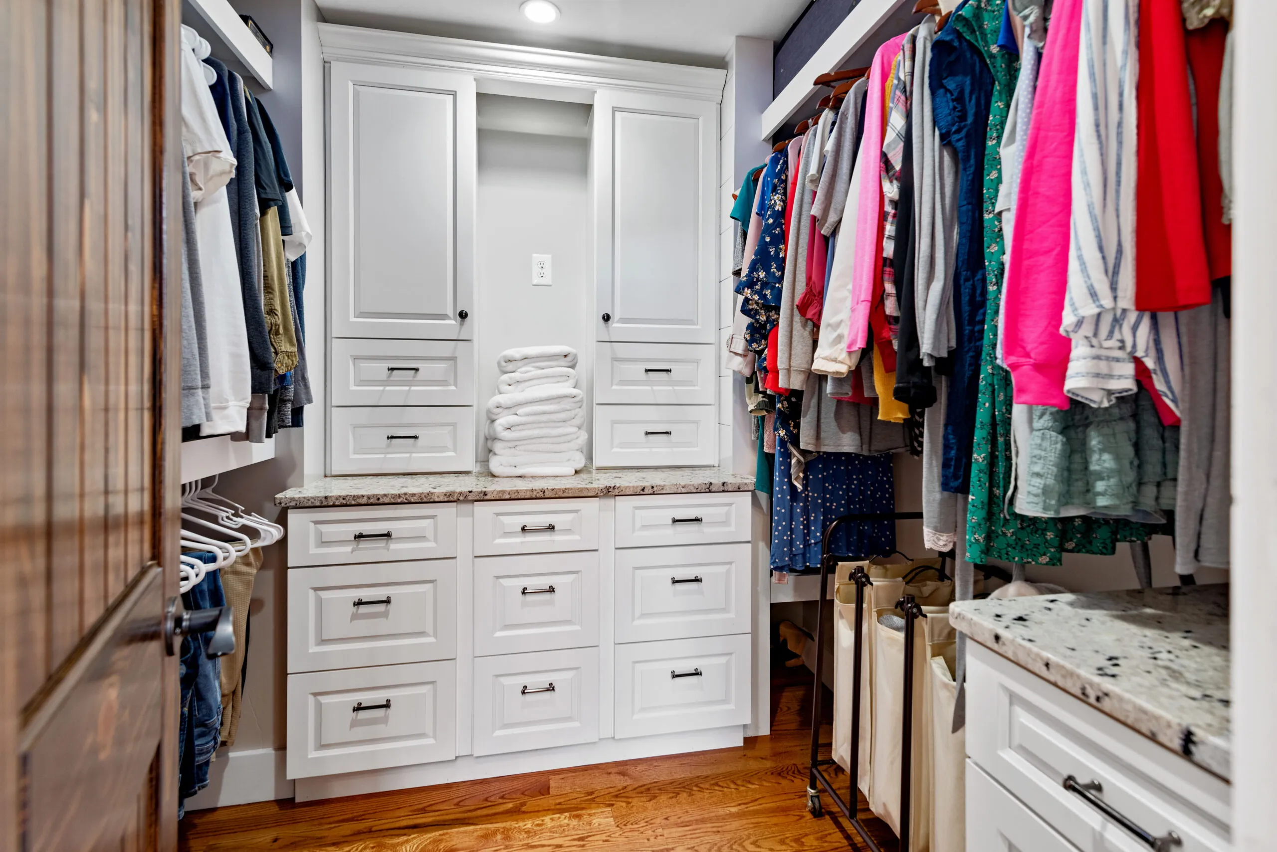 Walk-in closet with built-in white cabinets and drawers in the Lowry Home