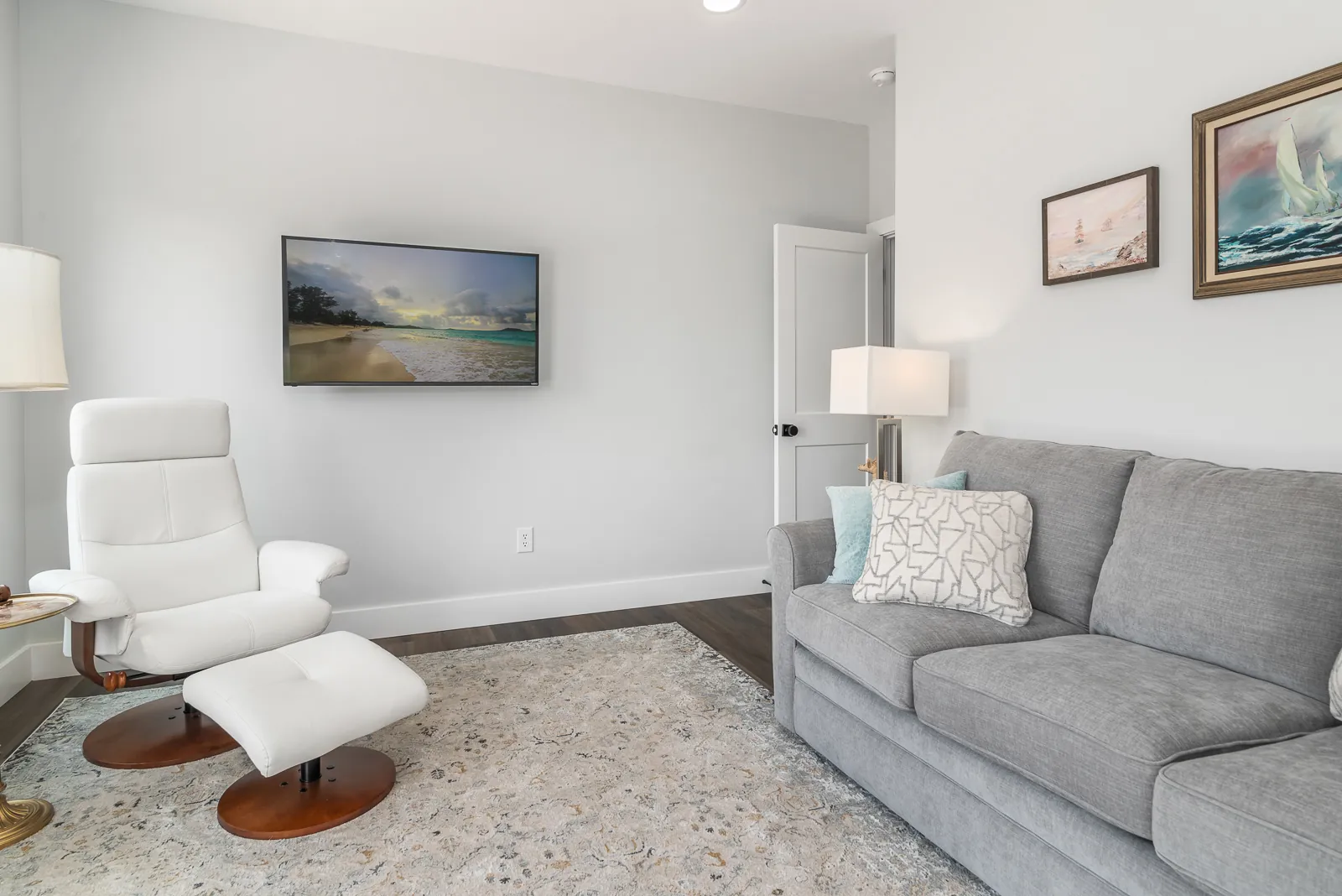 Sitting room with wall-mounted TV and gray sofa in the LynBrook Home