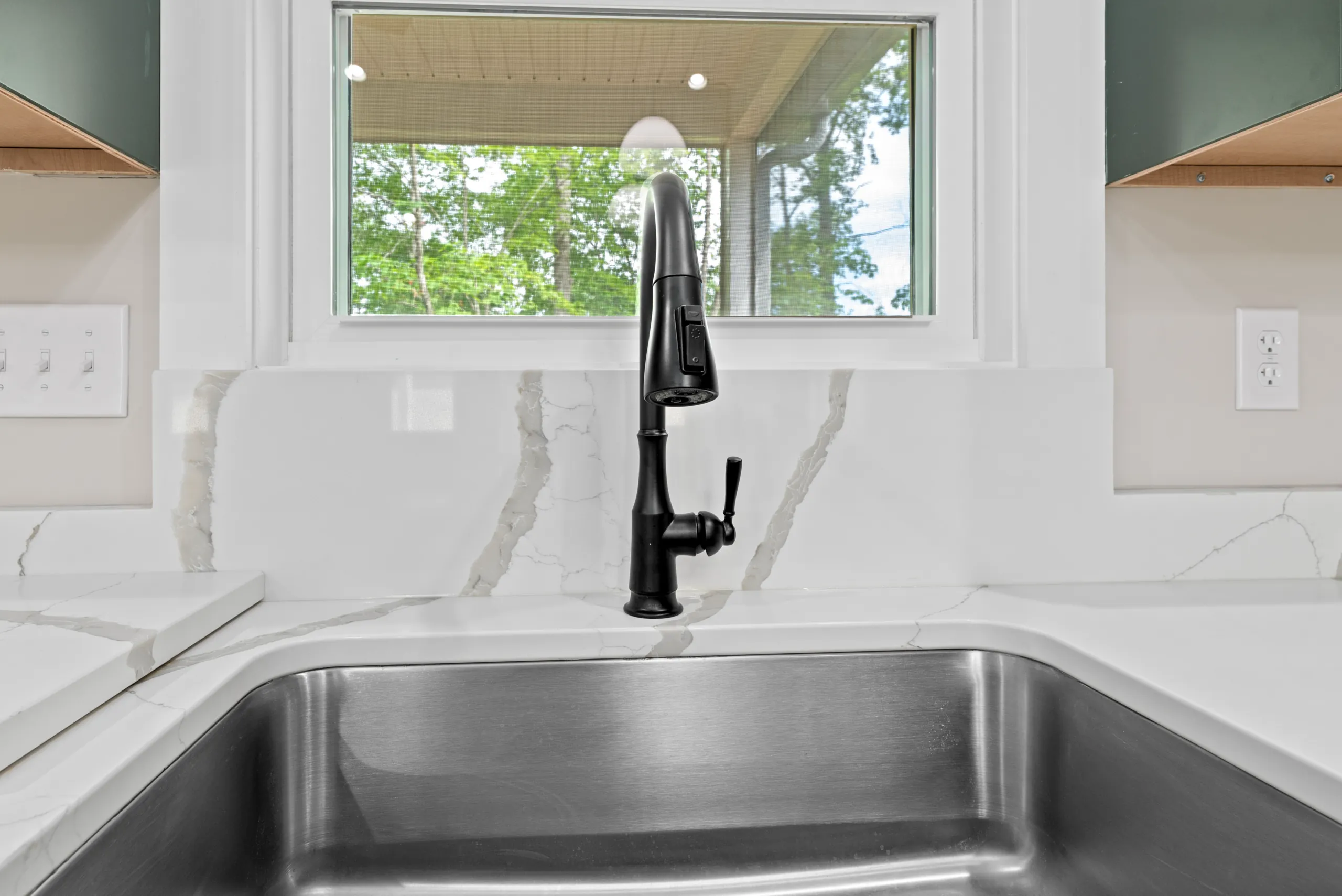 Matte black kitchen faucet at the sink window in the Lake Crest Home