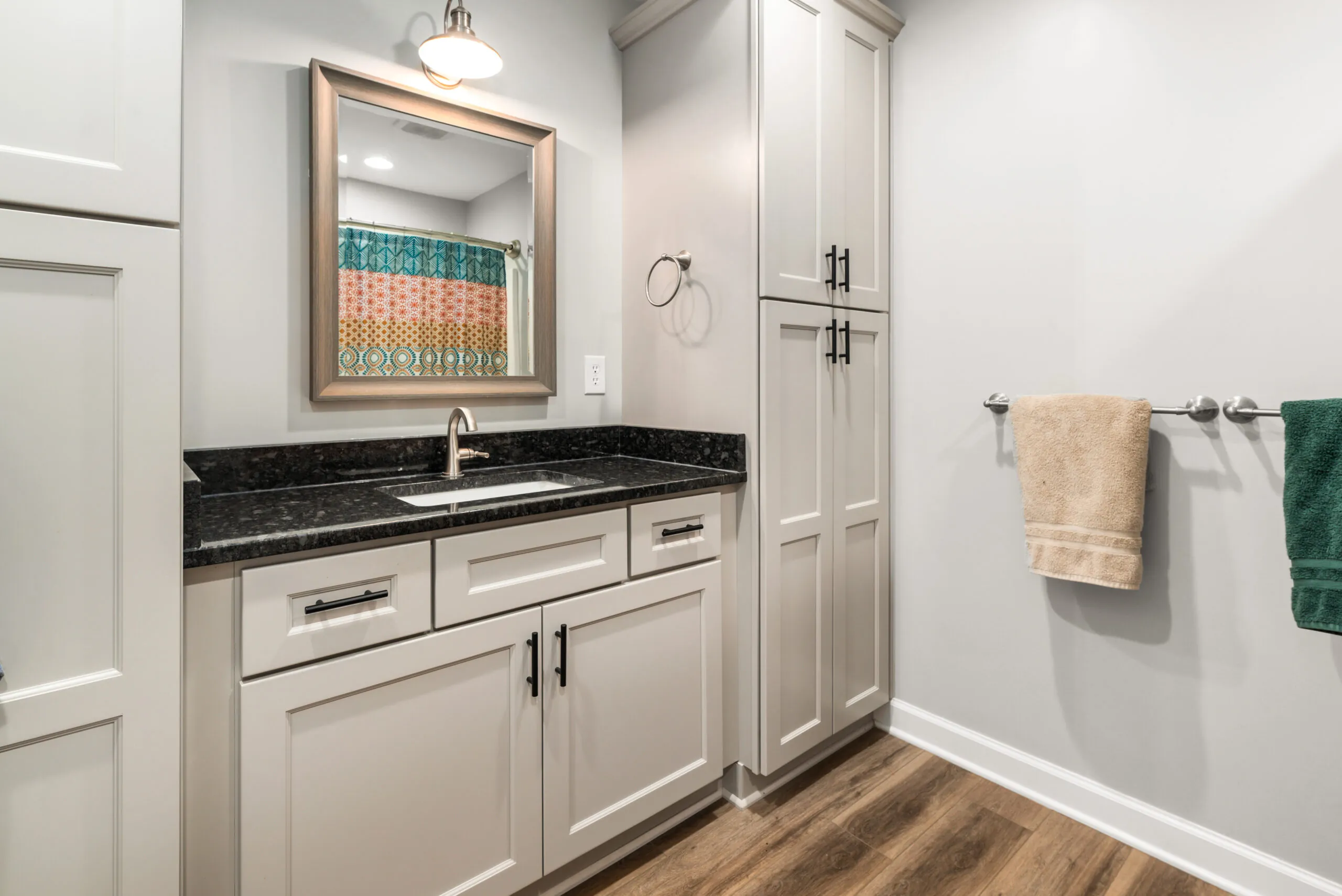 Full bathroom with granite vanity and tall linen cabinet in the Timber Ridge Home
