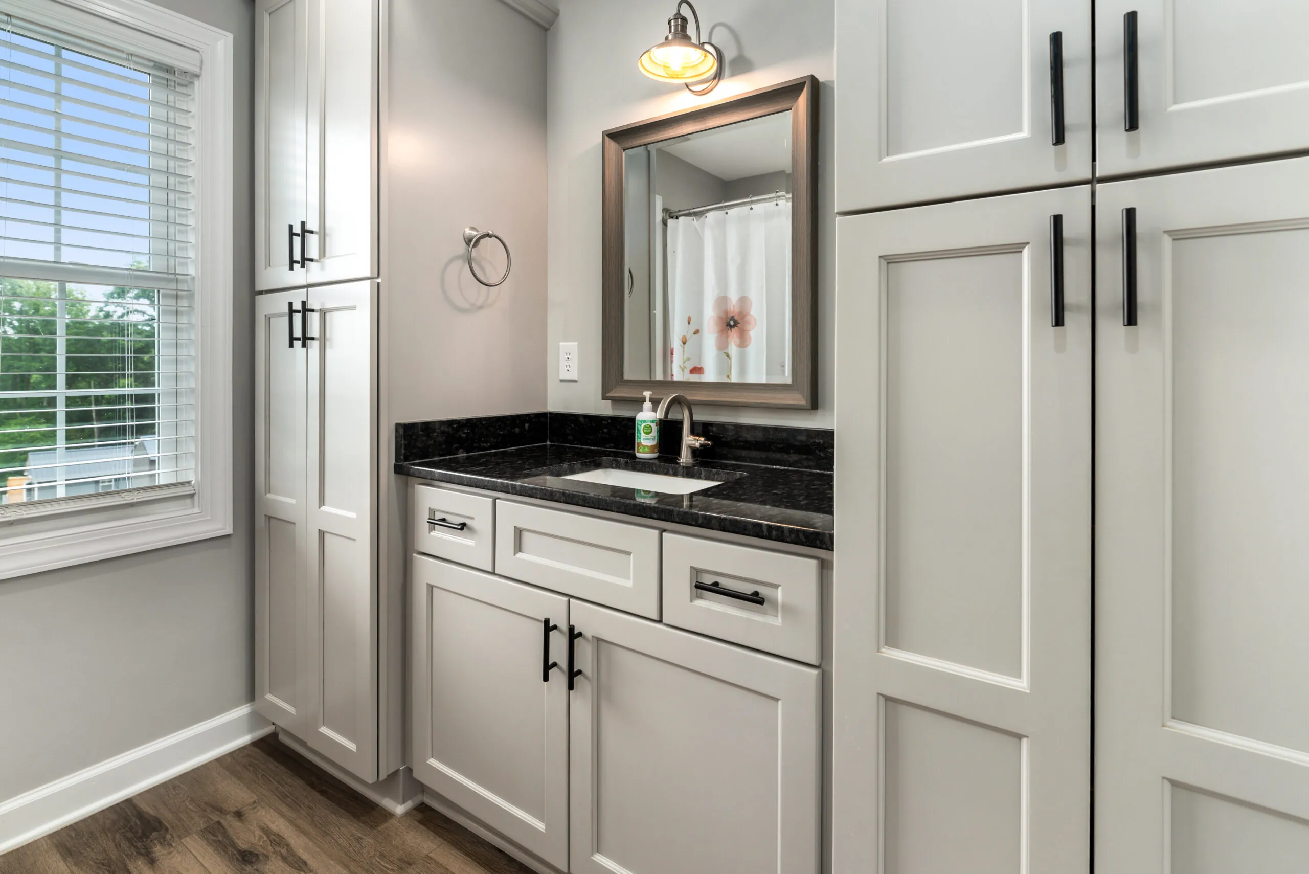 Bathroom vanity with black granite top and gray cabinets in the Timber Ridge Home