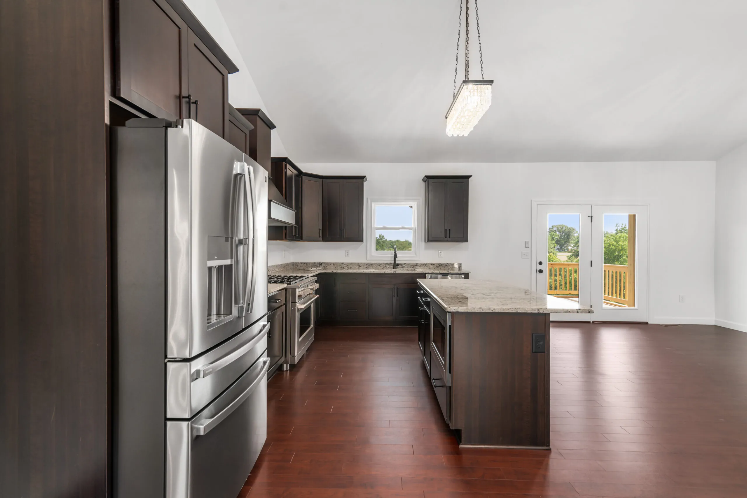 Open kitchen with island and stainless refrigerator in the Otterlea Home