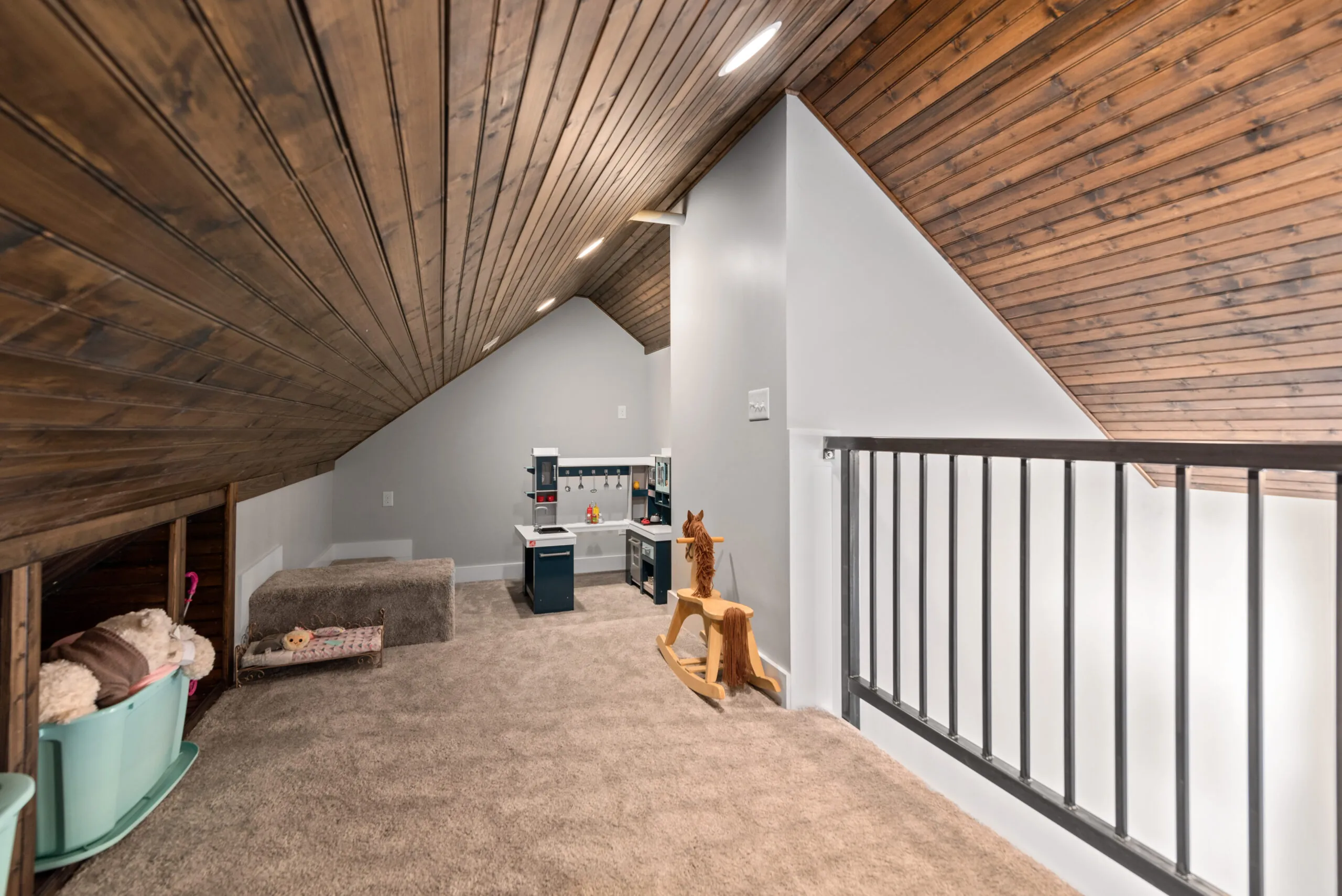 Loft play area under wood-paneled vaulted ceiling in the Lowry Home