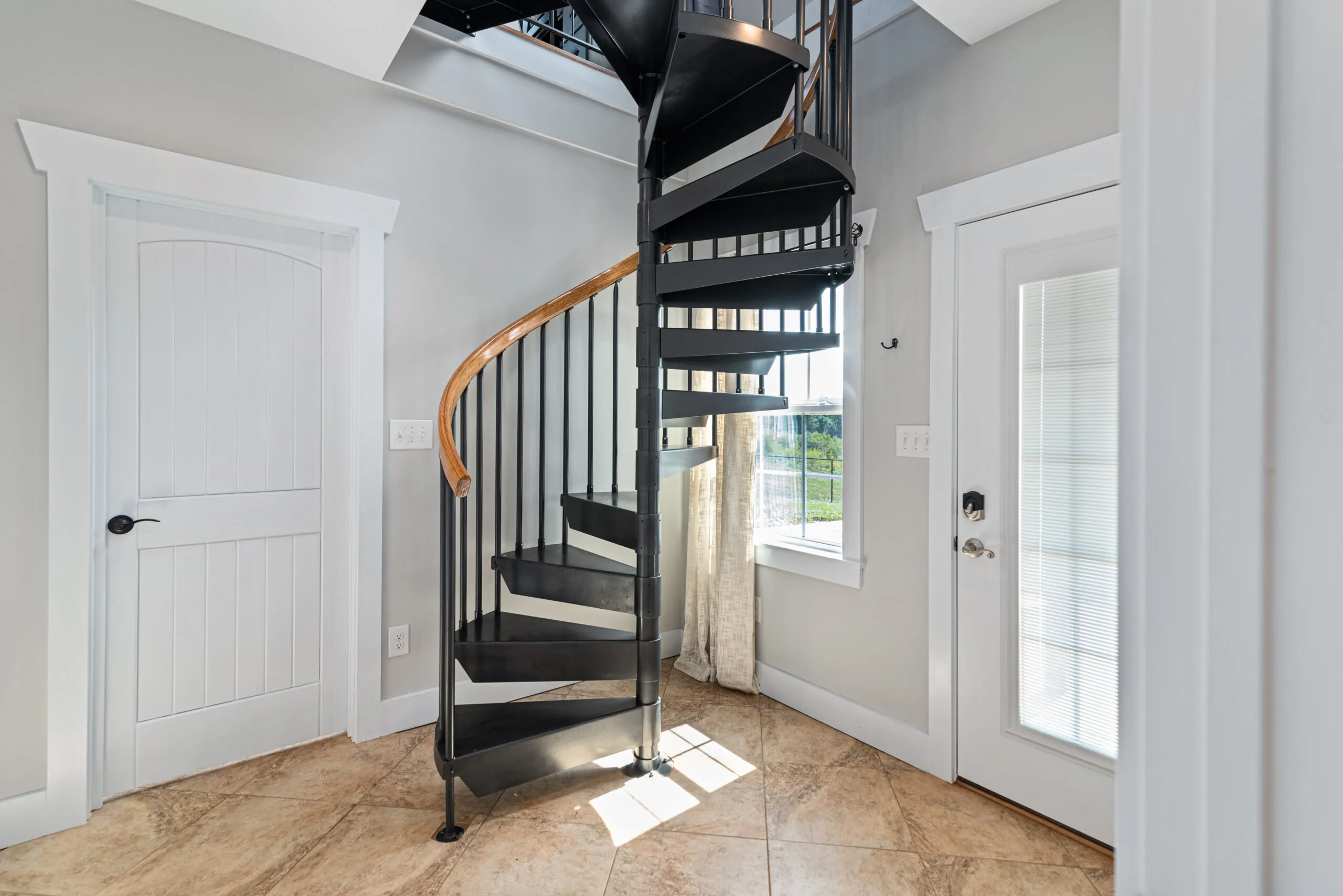 Black spiral staircase with wood handrail in the Lowry Home