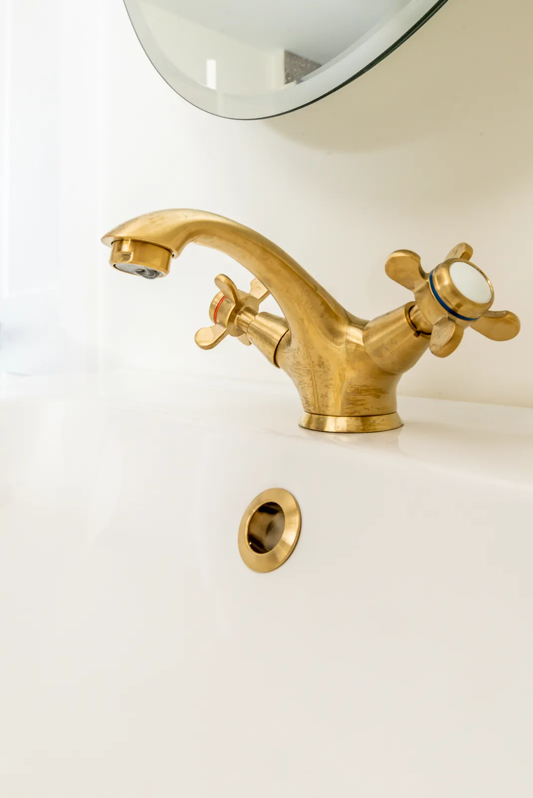Close-up of a brushed brass faucet on a white sink in the LynBrook Home