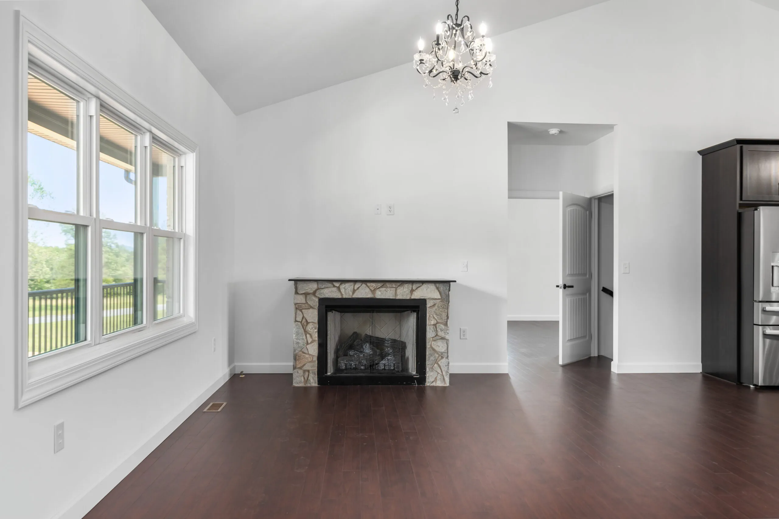 Stone fireplace and chandelier in the great room of the Otterlea Home