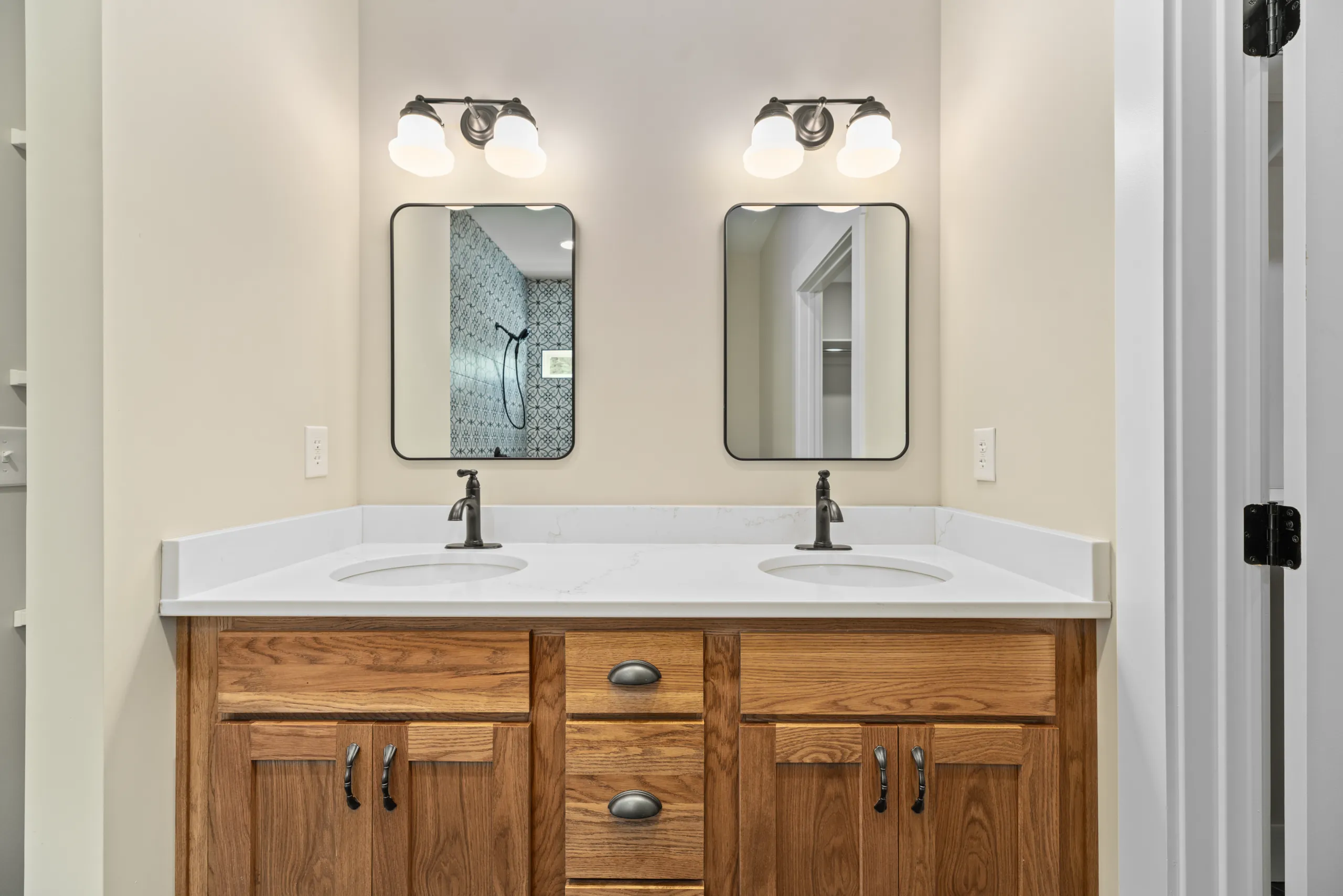 Primary bathroom double vanity with two mirrors in the Lake Crest Home