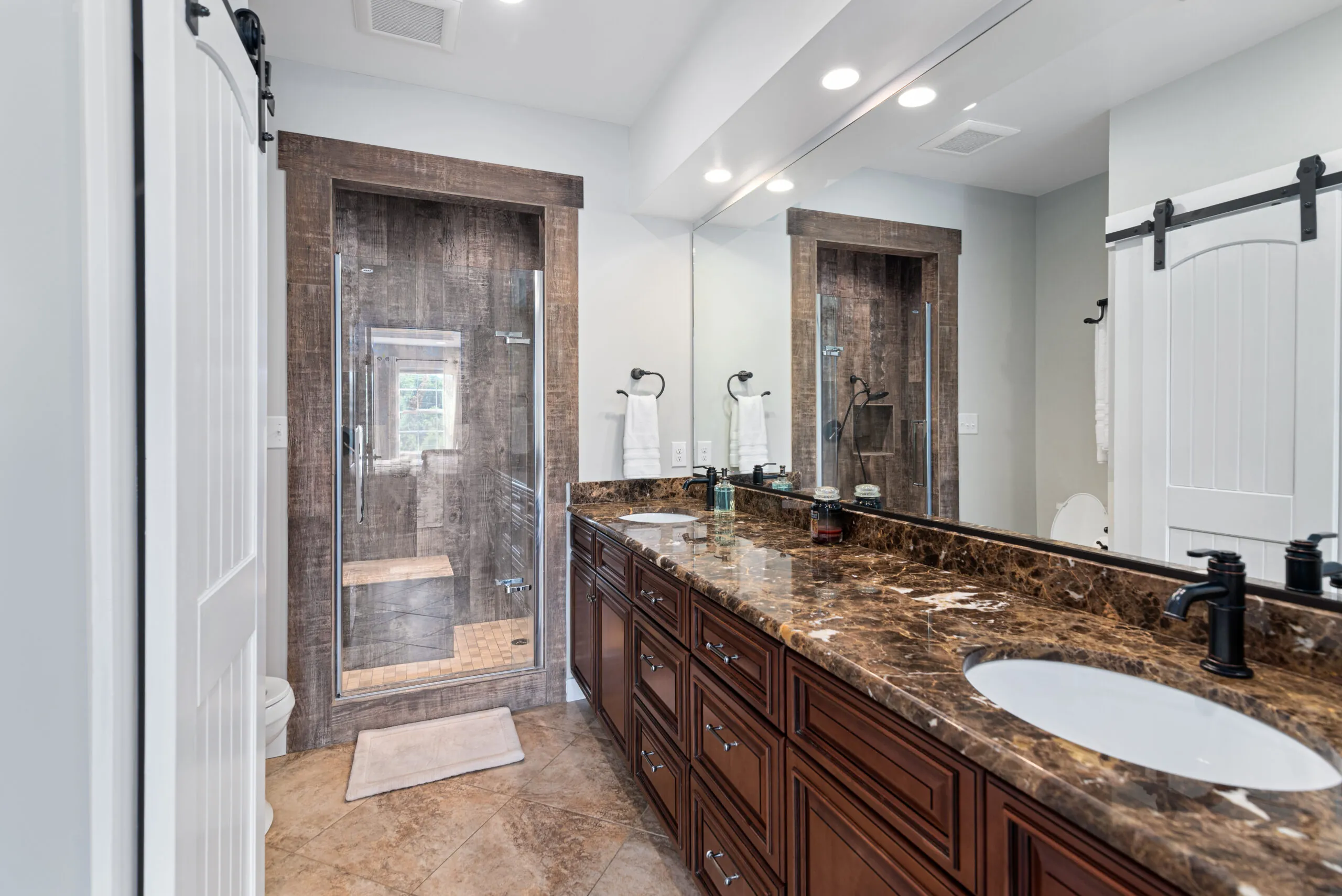 Primary bathroom with double marble vanity and barn doors in the Lowry Home